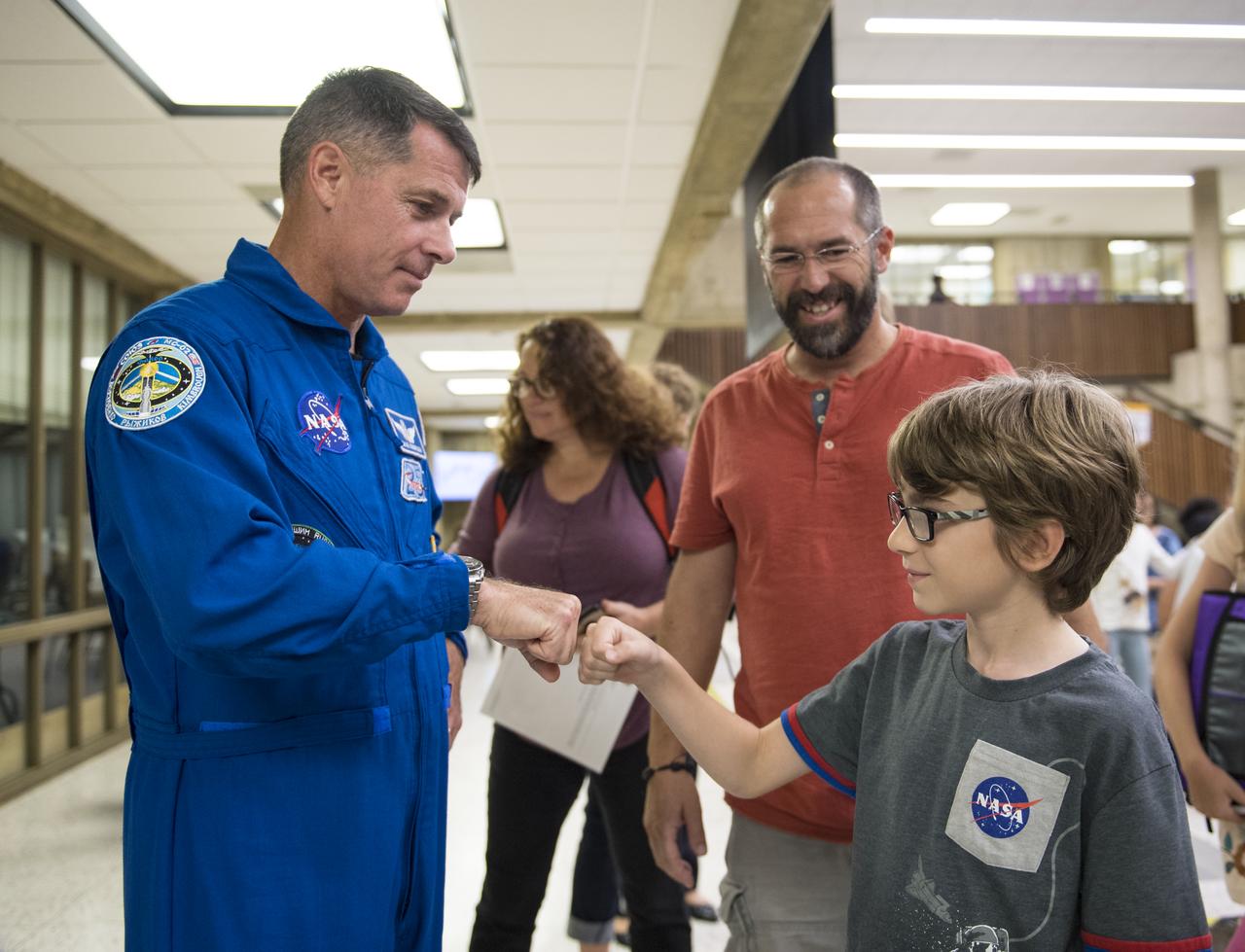 NASA astronaut Shane Kimbrough gives Nikola a fist bump after a presentation about his time onboard the International Space Station (ISS) during Expeditions 49/50, Tuesday, September 12, 2017 at Arlington Career Center in Arlington, Virginia. During Expedition 50, Kimbrough completed four spacewalks for a total of 39 hours outside the ISS, and concluded his 173-day mission when he landed in a remote area near the town of Zhezkazgan, Kazakhstan in April 2017. Photo Credit: (NASA/Aubrey Gemignani)