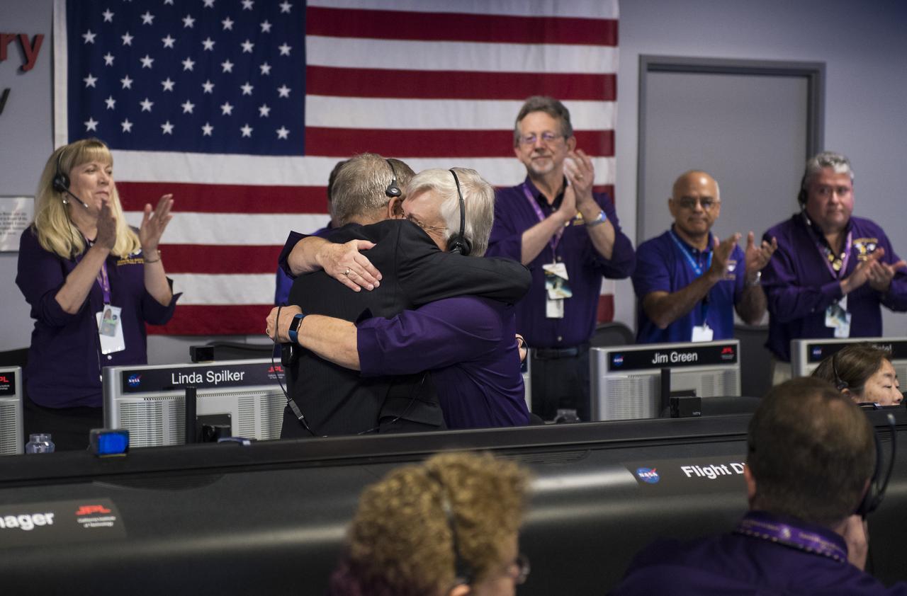 Cassini program manager at JPL, Earl Maize, left, and spacecraft operations team manager for the Cassini mission at Saturn, Julie Webster, right, embrace after the Cassini spacecraft plunged into Saturn, Friday, Sept. 15, 2017 at NASA's Jet Propulsion Laboratory in Pasadena, California. Since its arrival in 2004, the Cassini-Huygens mission has been a discovery machine, revolutionizing our knowledge of the Saturn system and captivating us with data and images never before obtained with such detail and clarity. On Sept. 15, 2017, operators will deliberately plunge the spacecraft into Saturn, as Cassini gathered science until the end. The “plunge” ensures Saturn’s moons will remain pristine for future exploration. During Cassini’s final days, mission team members from all around the world gathered at NASA’s Jet Propulsion Laboratory, Pasadena, California, to celebrate the achievements of this historic mission. Photo Credit: (NASA/Joel Kowsky)
