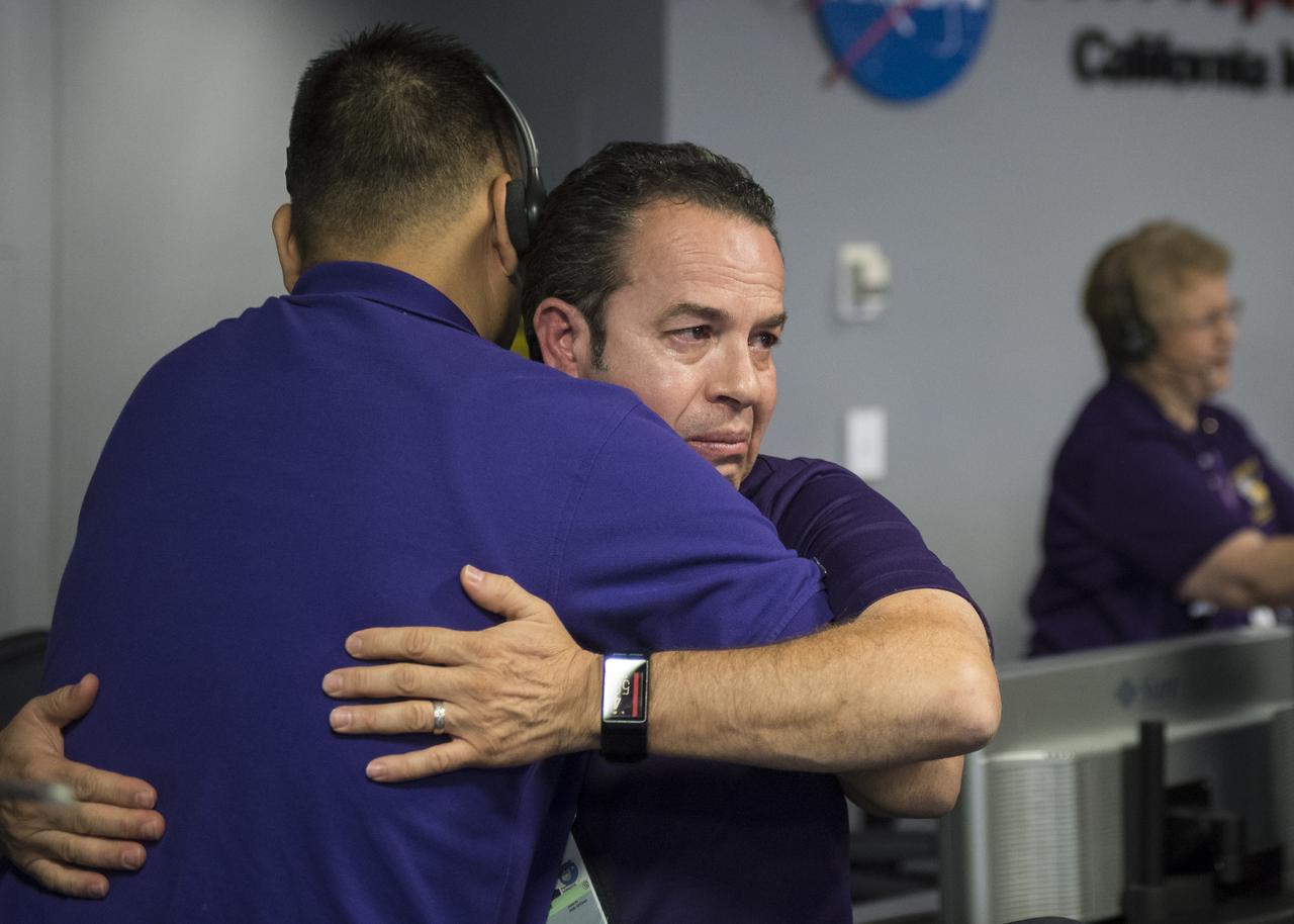 Cassini team members embrace after the spacecraft was deliberately plunged into Saturn, Friday, Sept. 15, 2017 at NASA's Jet Propulsion Laboratory in Pasadena, California. Since its arrival in 2004, the Cassini-Huygens mission has been a discovery machine, revolutionizing our knowledge of the Saturn system and captivating us with data and images never before obtained with such detail and clarity. On Sept. 15, 2017, operators deliberately plunged the spacecraft into Saturn, as Cassini gathered science until the end. Loss of contact with the Cassini spacecraft occurred at 7:55 a.m. EDT (4:55 a.m. PDT) The “plunge” ensures Saturn’s moons will remain pristine for future exploration. During Cassini’s final days, mission team members from all around the world gathered at NASA’s Jet Propulsion Laboratory, Pasadena, California, to celebrate the achievements of this historic mission. Photo Credit: (NASA/Joel Kowsky)