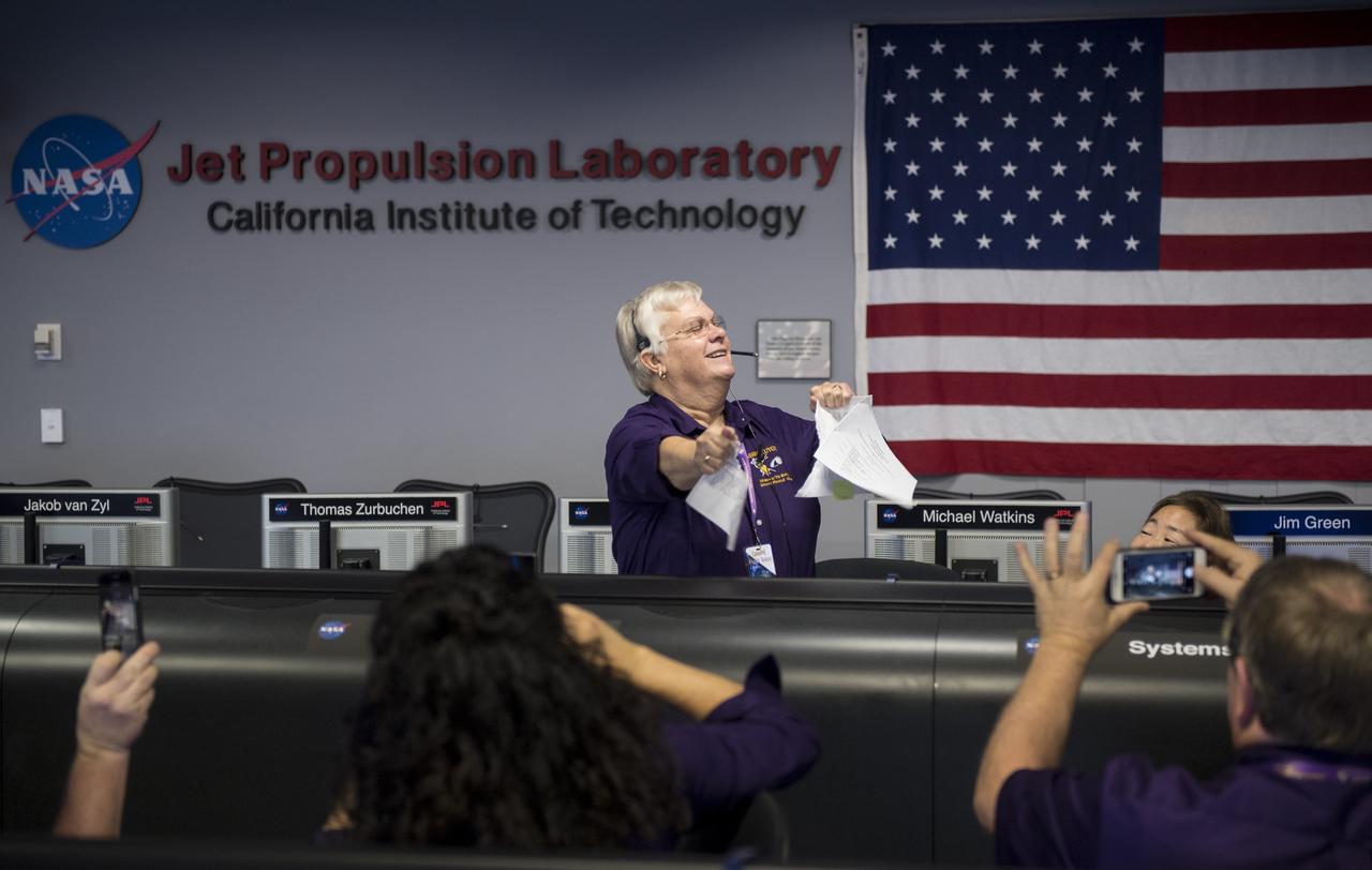 Spacecraft operations team manager for the Cassini mission at Saturn, Julie Webster, rips up the final contingency plan for the Cassini mission, Friday, Sept. 15, 2017 in mission control at NASA's Jet Propulsion Laboratory in Pasadena, California. Since its arrival in 2004, the Cassini-Huygens mission has been a discovery machine, revolutionizing our knowledge of the Saturn system and captivating us with data and images never before obtained with such detail and clarity. On Sept. 15, 2017, operators deliberately plunged the spacecraft into Saturn, as Cassini gathered science until the end. Loss of contact with the Cassini spacecraft occurred at 7:55 a.m. EDT (4:55 a.m. PDT). The “plunge” ensures Saturn’s moons will remain pristine for future exploration. During Cassini’s final days, mission team members from all around the world gathered at NASA’s Jet Propulsion Laboratory, Pasadena, California, to celebrate the achievements of this historic mission. Photo Credit: (NASA/Joel Kowsky)