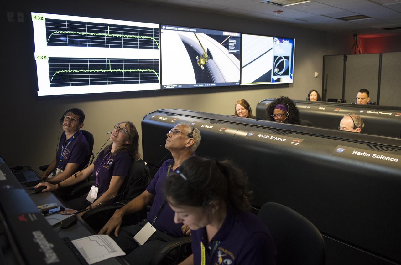 Zahi Tarzi, left, Julie Bellerose, center, and Duane Roth, right, of Cassini's navigation team watch data come in from the spacecraft during its final plunge into Saturn, Friday, Sept. 15, 2017 at NASA's Jet Propulsion Laboratory in Pasadena, California. Since its arrival in 2004, the Cassini-Huygens mission has been a discovery machine, revolutionizing our knowledge of the Saturn system and captivating us with data and images never before obtained with such detail and clarity. On Sept. 15, 2017, operators deliberately plunged the spacecraft into Saturn, as Cassini gathered science until the end. Loss of contact with the Cassini spacecraft occurred at 7:55 a.m. EDT (4:55 a.m. PDT). The “plunge” ensures Saturn’s moons will remain pristine for future exploration. During Cassini’s final days, mission team members from all around the world gathered at NASA’s Jet Propulsion Laboratory, Pasadena, California, to celebrate the achievements of this historic mission. Photo Credit: (NASA/Joel Kowsky)