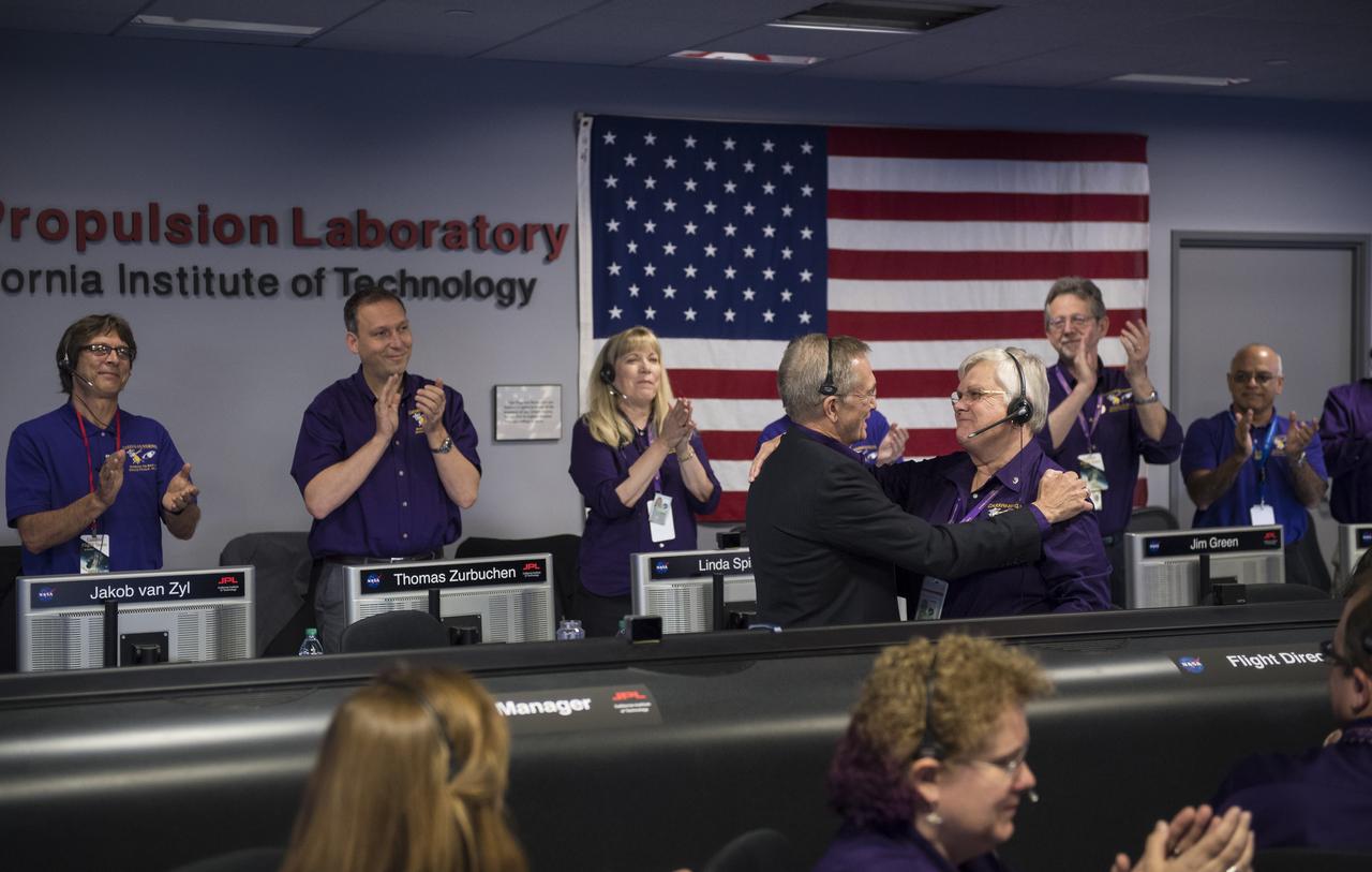 Cassini program manager at JPL, Earl Maize, left, and spacecraft operations team manager for the Cassini mission at Saturn, Julie Webster, right, embrace after the Cassini spacecraft plunged into Saturn, Friday, Sept. 15, 2017 at NASA's Jet Propulsion Laboratory in Pasadena, California. Since its arrival in 2004, the Cassini-Huygens mission has been a discovery machine, revolutionizing our knowledge of the Saturn system and captivating us with data and images never before obtained with such detail and clarity. On Sept. 15, 2017, operators will deliberately plunge the spacecraft into Saturn, as Cassini gathered science until the end. The “plunge” ensures Saturn’s moons will remain pristine for future exploration. During Cassini’s final days, mission team members from all around the world gathered at NASA’s Jet Propulsion Laboratory, Pasadena, California, to celebrate the achievements of this historic mission. Photo Credit: (NASA/Joel Kowsky)