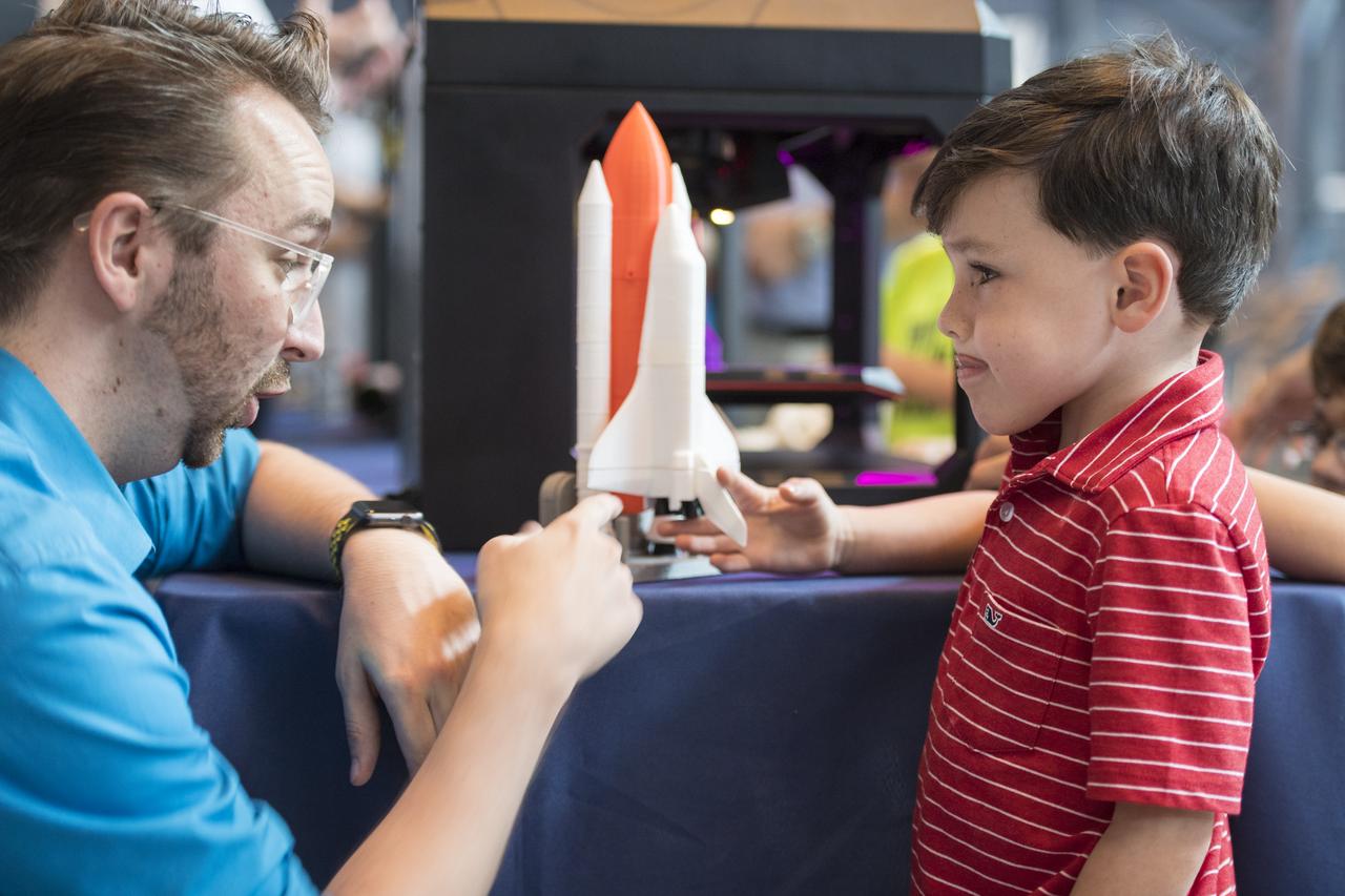 A visitor learns about 3D printing at a pop-up makerspace  held by Future Engineers with support from NASA and The American Society of Mechanical Engineers (ASME), at the Steven F. Udvar-Hazy Center, Thursday, September 21, 2017 in Chantilly, Virginia. Participants created digital 3D models using Autodesk Tinkercad and watched objects being printed with Makerbot 3D printers. Photo Credit: (NASA/Aubrey Gemignani)