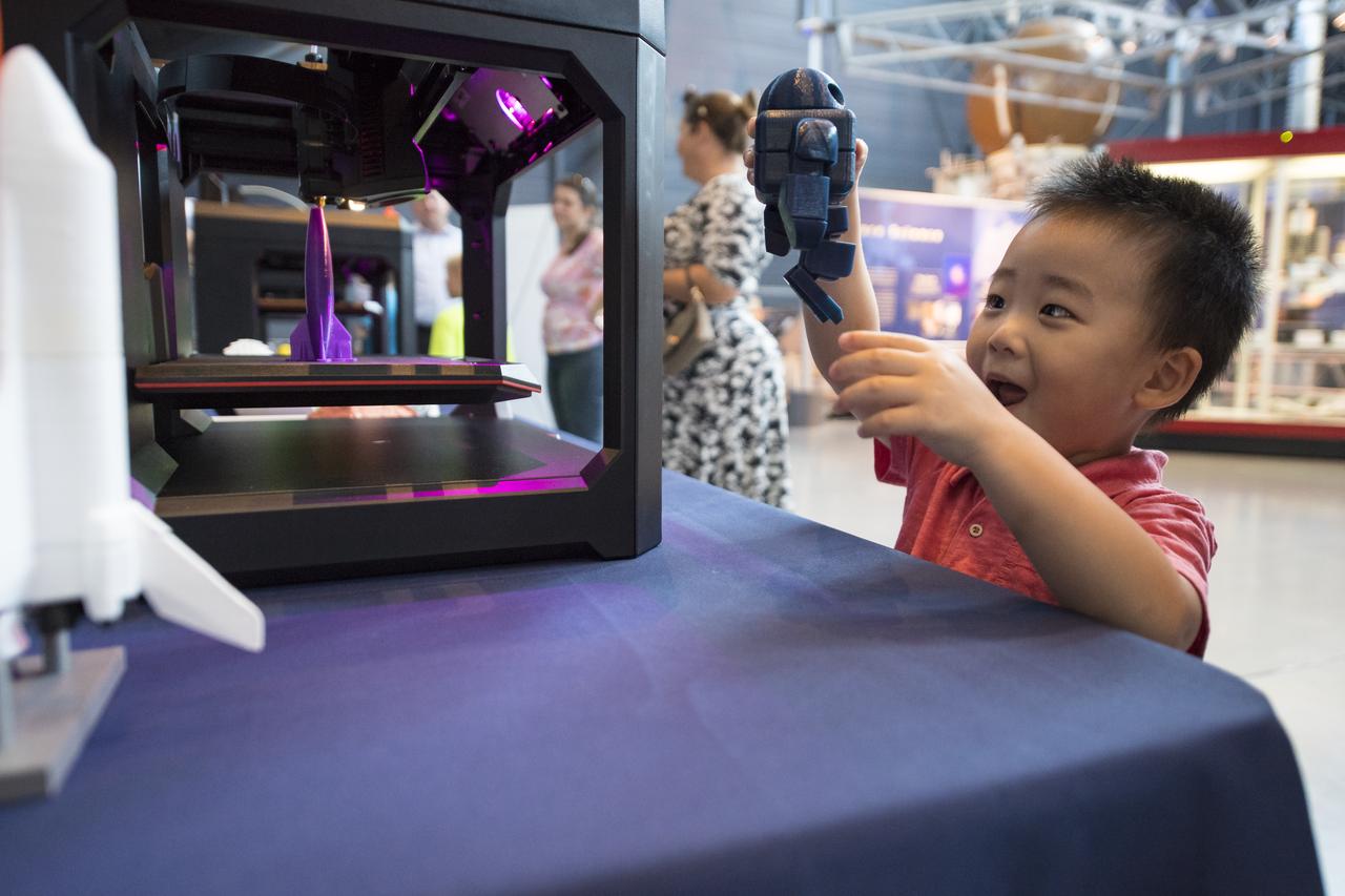 A visitor plays with a robot printed by a 3D printer at a pop-up makerspace held by Future Engineers with support from NASA and The American Society of Mechanical Engineers (ASME), at the Steven F. Udvar-Hazy Center, Thursday, September 21, 2017 in Chantilly, Virginia. Participants created digital 3D models using Autodesk Tinkercad and watched objects being printed with Makerbot 3D printers. Photo Credit: (NASA/Aubrey Gemignani)