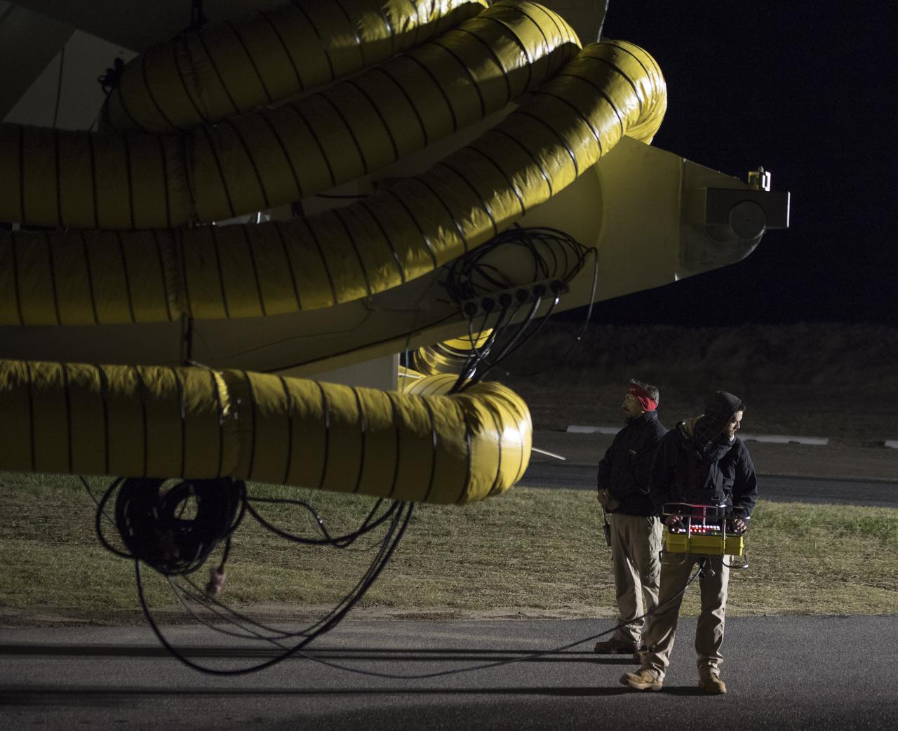 Orbital ATK Mechanical Technician Phil Kauthen drives the transporter with the Antares rocket aboard from the Horizontal Integration Facility to launch Pad-0A, Thursday, Nov. 9, 2017 at NASA's Wallops Flight Facility in Virginia. Orbital ATK’s eighth contracted cargo resupply mission with NASA to the International Space Station will deliver over 7,400 pounds of science and research, crew supplies and vehicle hardware to the orbital laboratory and its crew. Photo Credit: (NASA/Bill Ingalls)