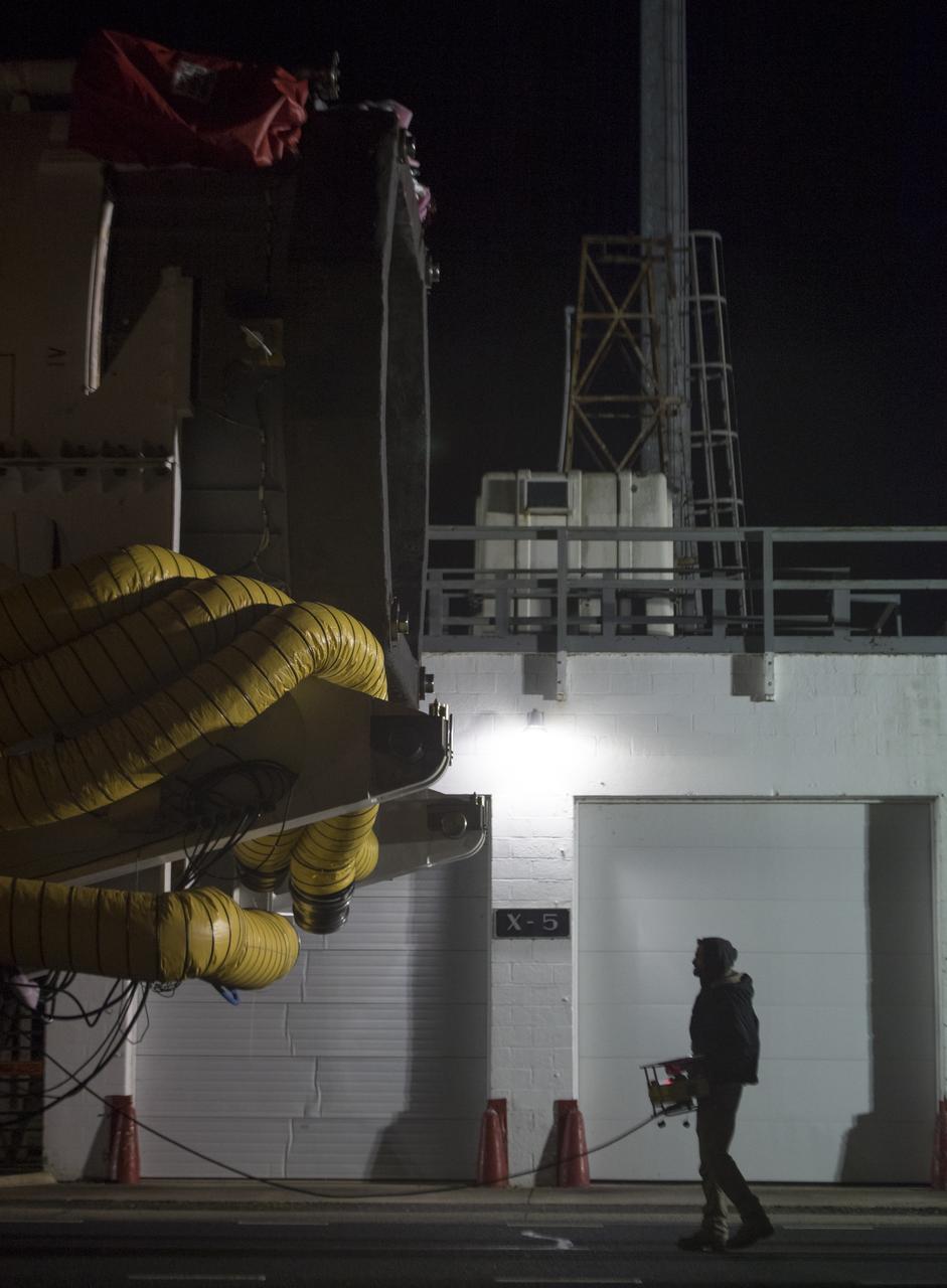 Orbital ATK Mechanical Technician Phil Kauthen drives the transporter with the Antares rocket aboard from the Horizontal Integration Facility to launch Pad-0A, Thursday, Nov. 9, 2017 at NASA's Wallops Flight Facility in Virginia. Orbital ATK’s eighth contracted cargo resupply mission with NASA to the International Space Station will deliver over 7,400 pounds of science and research, crew supplies and vehicle hardware to the orbital laboratory and its crew. Photo Credit: (NASA/Bill Ingalls)