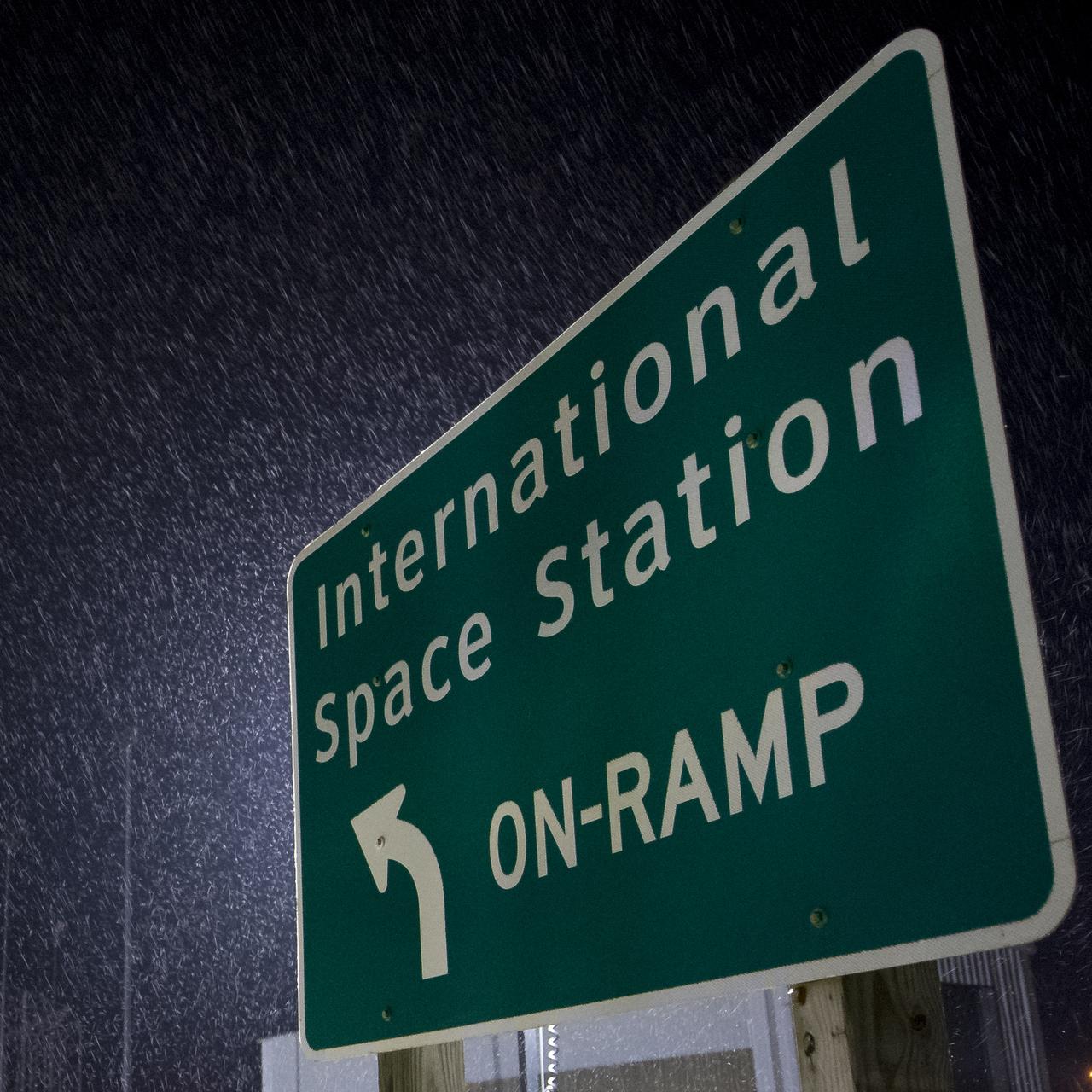 A sign at the entrance launch Pad-0A is seen as the Orbital ATK Antares rocket is rolled from the Horizontal Integration Facility (HIF) to the pad, Thursday, Nov. 9, 2017 at NASA's Wallops Flight Facility in Virginia. Orbital ATK’s eighth contracted cargo resupply mission with NASA to the International Space Station will deliver over 7,400 pounds of science and research, crew supplies and vehicle hardware to the orbital laboratory and its crew. Photo Credit: (NASA/Bill Ingalls)