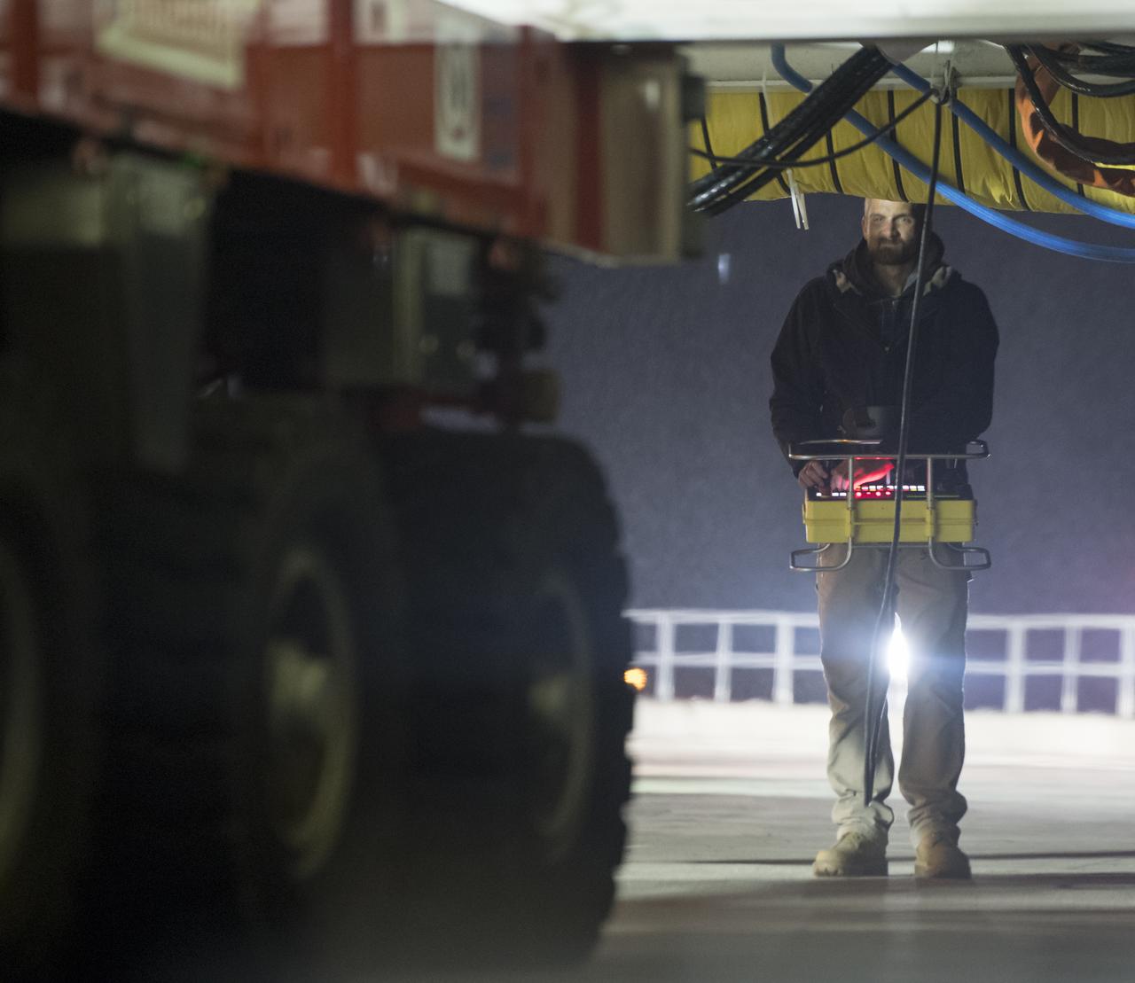 Orbital ATK Mechanical Technician Phil Kauthen drives the transporter with the Antares rocket aboard from the Horizontal Integration Facility to launch Pad-0A, Thursday, Nov. 9, 2017 at NASA's Wallops Flight Facility in Virginia. Orbital ATK’s eighth contracted cargo resupply mission with NASA to the International Space Station will deliver over 7,400 pounds of science and research, crew supplies and vehicle hardware to the orbital laboratory and its crew. Photo Credit: (NASA/Bill Ingalls)