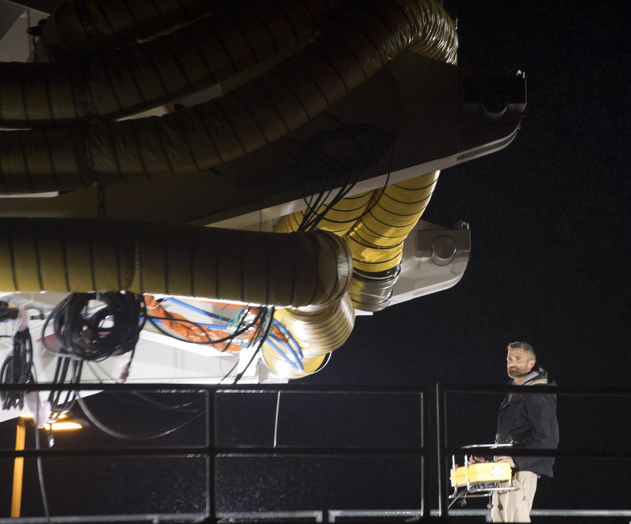Orbital ATK Mechanical Technician Phil Kauthen drives the transporter with the Antares rocket aboard from the Horizontal Integration Facility to launch Pad-0A, Thursday, Nov. 9, 2017 at NASA's Wallops Flight Facility in Virginia. Orbital ATK’s eighth contracted cargo resupply mission with NASA to the International Space Station will deliver over 7,400 pounds of science and research, crew supplies and vehicle hardware to the orbital laboratory and its crew. Photo Credit: (NASA/Bill Ingalls)