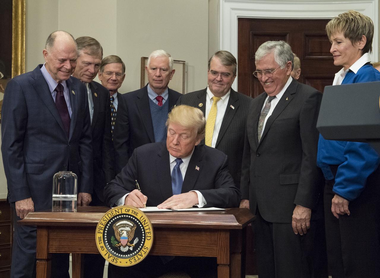 President Donald Trump signs Space Policy Directive - 1, directing NASA to return to the moon, alongside members of the Senate, Congress, NASA, and commercial space companies in the Roosevelt room of the White House in Washington, Monday, Dec. 11, 2017. Photo Credit: (NASA/Aubrey Gemignani)