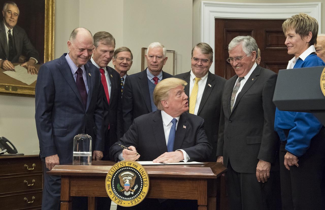 President Donald Trump prepares to sign Space Policy Directive - 1, directing NASA to return to the moon, alongside members of the Senate, Congress, NASA, and commercial space companies in the Roosevelt room of the White House in Washington, Monday, Dec. 11, 2017. Photo Credit: (NASA/Aubrey Gemignani)