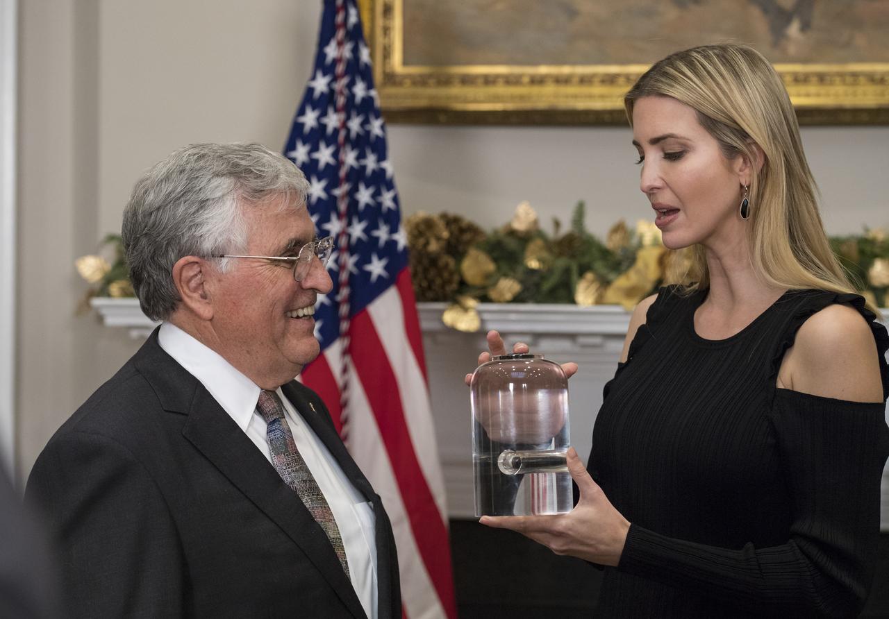 Ivanka Trump, advisor to President Donald Trump, touches a sample from the moon that former astronaut Jack Schmitt, left, collected during the Apollo 17 mission, just after President Trump signed Space Policy Directive - 1, directing NASA to return to the moon, in the Roosevelt room of the White House in Washington, Monday, Dec. 11, 2017. Photo Credit: (NASA/Aubrey Gemignani)