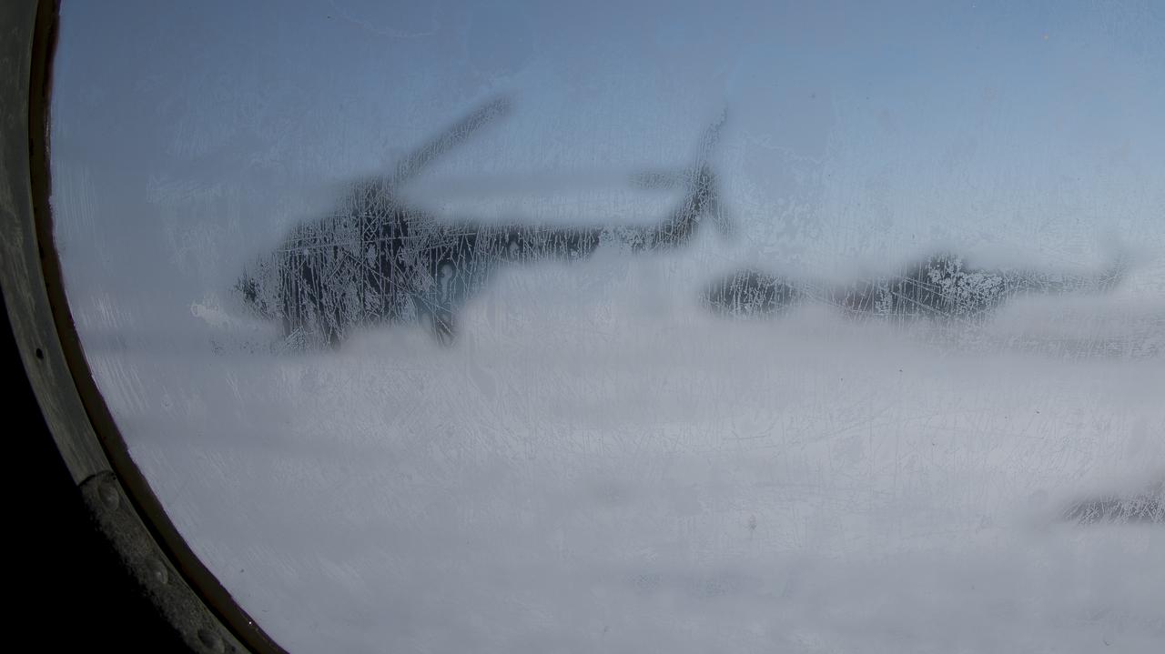 Russian helicopters are seen through the frozen window of another helicopter as teams prepare for the Soyuz MS-05 landing with Expedition 53 Commander Randy Bresnik of NASA and Flight Engineers Paolo Nespoli of ESA (European Space Agency) and Sergey Ryazanskiy of the Russian space agency Roscosmos near the town of Zhezkazgan, Kazakhstan on Thursday, Dec. 14, 2017. Bresnik, Nespoli and Ryazanskiy are returning after 139 days in space where they served as members of the Expedition 52 and 53 crews onboard the International Space Station. Photo Credit: (NASA/Bill Ingalls)