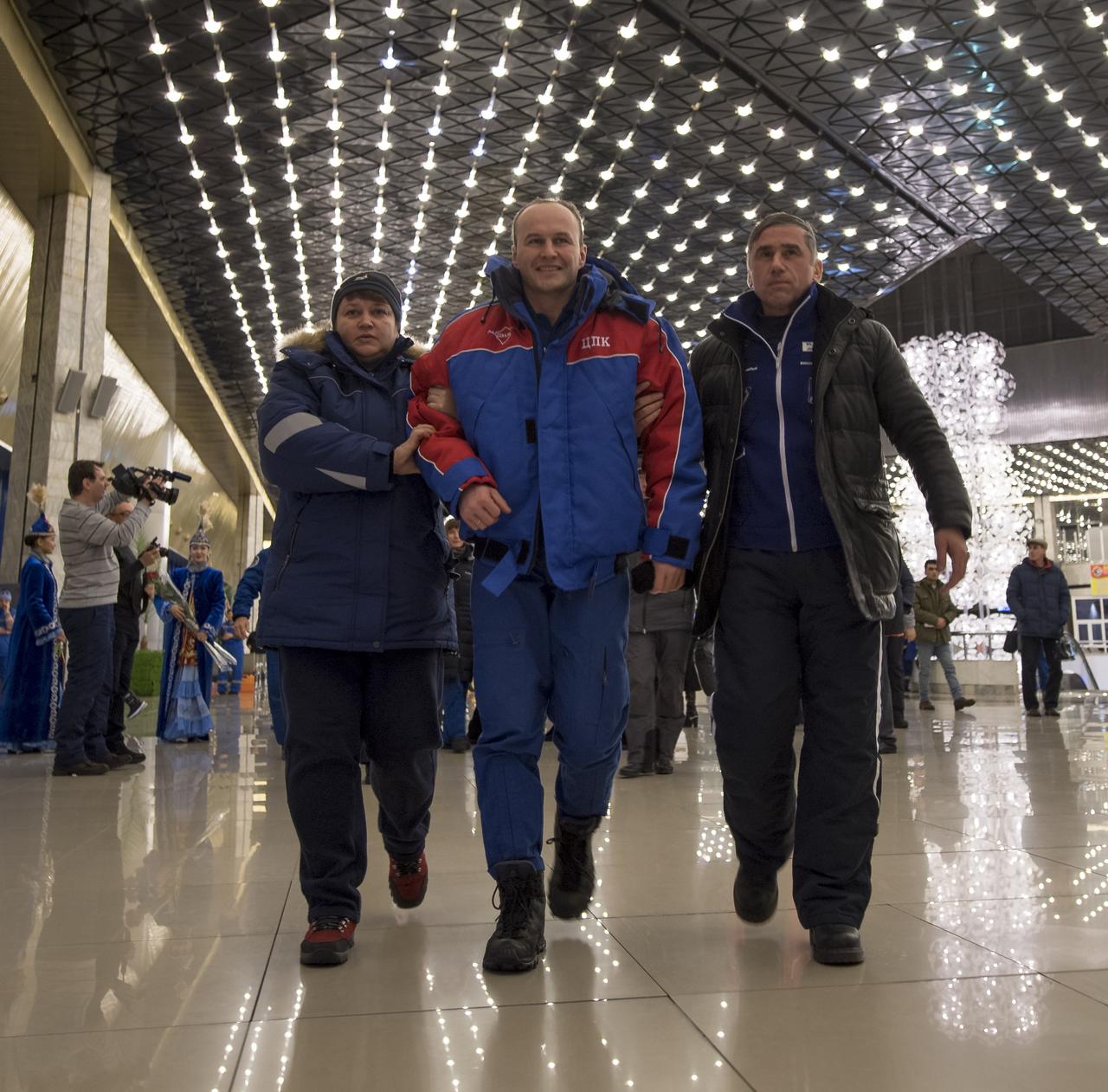 Roscosmos cosmonaut Sergey Ryazanskiy, center, arrives at the Karaganda Airport in Kazakhstan airport after he, NASA astronaut Randy Bresnik and, ESA (European Space Agency) astronaut Paolo Nespoli landed in their Soyuz MS-05 spacecraft in a remote area near the town of Zhezkazgan, Kazakhstan on Thursday, Dec. 14, 2017. Bresnik, Nespoli and Ryazanskiy are returning after 139 days in space where they served as members of the Expedition 52 and 53 crews onboard the International Space Station. Photo Credit: (NASA/Bill Ingalls)