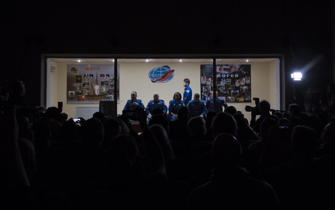 Expedition 54 prime crew members flight engineer Norishige Kanai of the Japan Aerospace Exploration Agency (JAXA), Soyuz Commander Anton Shkaplerov of Roscosmos, flight engineer Scott Tingle of NASA, along with backup crew members Jeanette Epps of NASA, Sergey Prokopev of Roscosmos, and Alex Gerst of ESA (European Space Agency), are seen as they enter a room for a press conference, Saturday, Dec. 16, 2017 at the Cosmonaut Hotel in Baikonur, Kazakhstan. Expedition 54 Soyuz Commander Anton Shkaplerov of Roscosmos, flight engineer Scott Tingle of NASA, and flight engineer Norishige Kanai of Japan Aerospace Exploration Agency (JAXA) are scheduled to launch to the International Space Station aboard the Soyuz spacecraft from the Baikonur Cosmodrome on December 17.  Photo Credit: (NASA/Joel Kowsky)