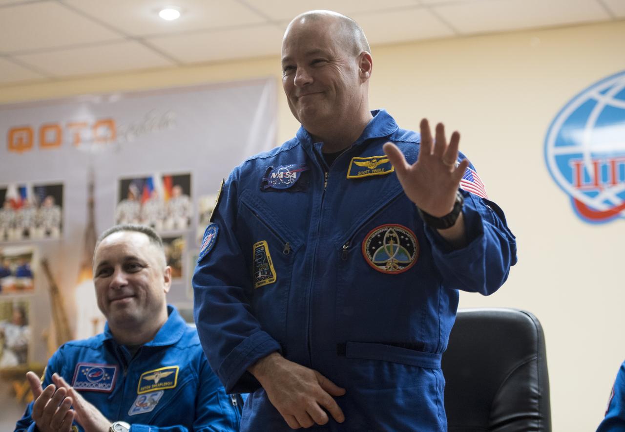 Expedition 54 flight engineer Scott Tingle is seen in quarantine, behind glass, during a press conference, Saturday, Dec. 16, 2017 at the Cosmonaut Hotel in Baikonur, Kazakhstan. Tingle, Soyuz Commander Anton Shkaplerov of Roscosmos, and flight engineer Norishige Kanai of the Japan Aerospace Exploration Agency (JAXA) are scheduled to launch to the International Space Station aboard the Soyuz spacecraft from the Baikonur Cosmodrome on December 17.  Photo Credit: (NASA/Joel Kowsky)