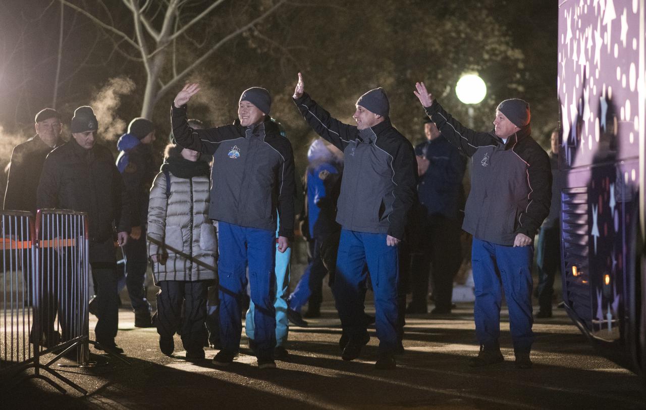 Expedition 54 flight engineer Norishige Kanai of the Japan Aerospace Exploration Agency (JAXA), left, Soyuz Commander Anton Shkaplerov of Roscosmos, center, and flight engineer Scott Tingle of NASA, right, wave farewell to family and friends as they depart the Cosmonaut Hotel to suit-up for their Soyuz launch to the International Space Station, Sunday, Dec. 17, 2017 in Baikonur, Kazakhstan. Launch of the Soyuz rocket is scheduled for 2:21 a.m. Eastern Time (1:21 p.m. Baikonur time) on December 17 and will send Shkaplerov, Tingle, and Kanai on a five month mission aboard the International Space Station.  Photo Credit: (NASA/Joel Kowsky)