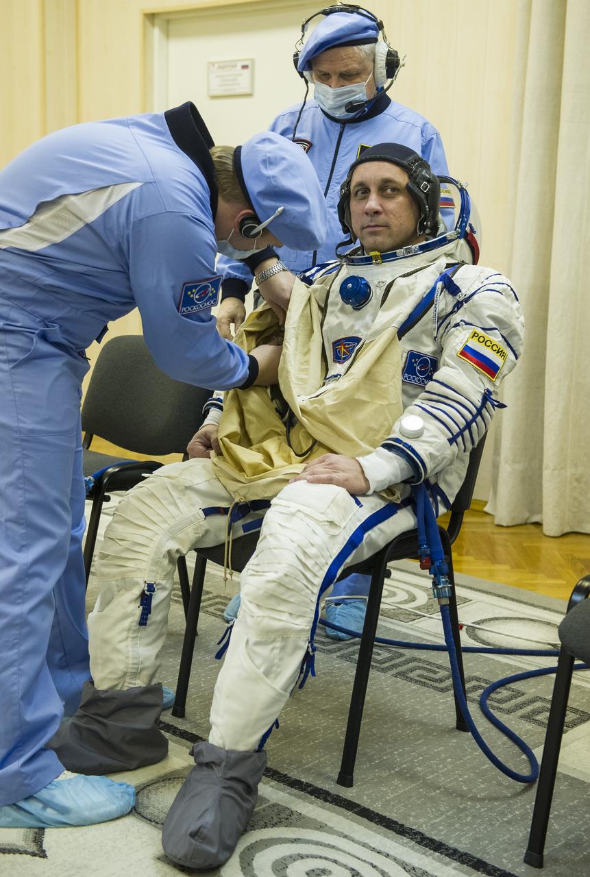 Expedition 54 Soyuz Commander Anton Shkaplerov of Roscosmos is helped into his Russian Sokol suit as he and fellow cremates, flight engineer Norishige Kanai of Japan Aerospace Exploration Agency (JAXA) and flight engineer Scott Tingle of NASA prepare for their Soyuz launch to the International Space Station Sunday, Dec. 17, 2017 in Baikonur, Kazakhstan.  Launch of the Soyuz rocket will send Tingle, Kanai, and Shkaplerov on a five month mission aboard the International Space Station. Photo Credit: (NASA/GCTC/Andrey Shelepin)