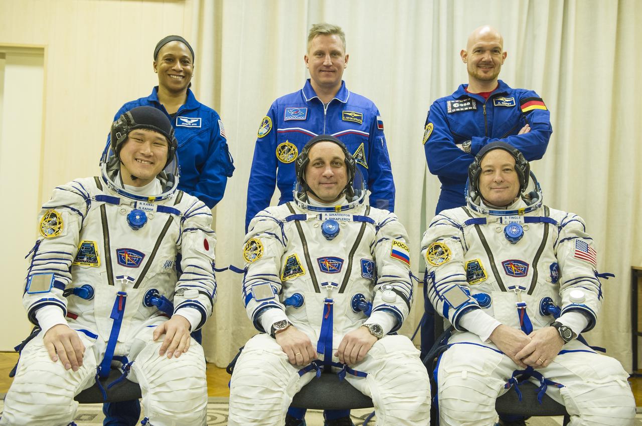 Expedition 54 prime crew members flight engineer Norishige Kanai of Japan Aerospace Exploration Agency (JAXA), left, Soyuz Commander Anton Shkaplerov of Roscosmos, center, and flight engineer Scott Tingle of NASA, right, pose for a picture with backup crew members  of NASA, right, Sergey Prokopev of Roscosmos, center, and Alex Gerst of ESA (European Space Agency), right after donning their Russian Sokol suits in preparation for launch to the International Space Station Sunday, Dec. 17, 2017 in Baikonur, Kazakhstan.  Launch of the Soyuz rocket will send Tingle, Kanai, and Shkaplerov on a five month mission aboard the International Space Station. Photo Credit: (NASA/GCTC/Andrey Shelepin)
