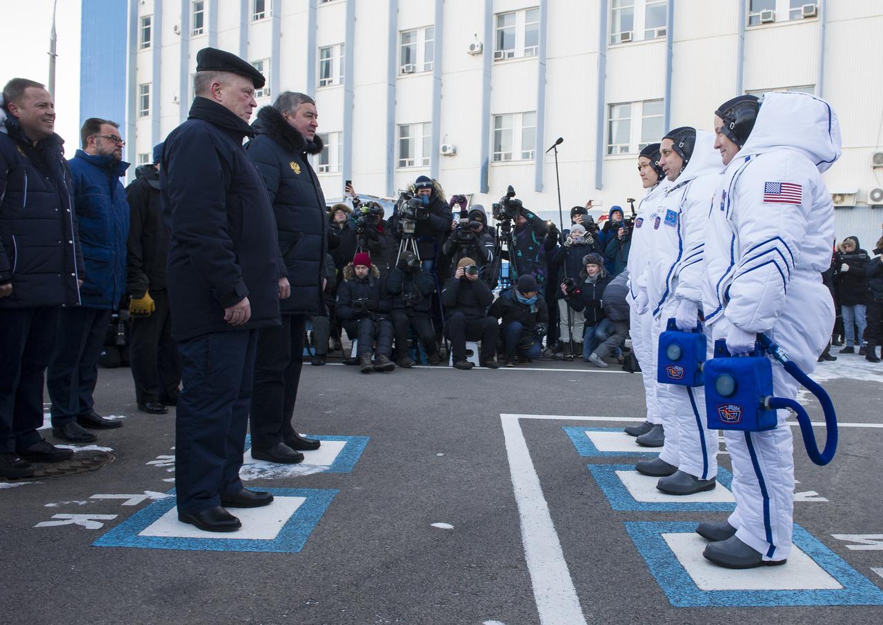 Expedition 54 flight engineer Norishige Kanai of Japan Aerospace Exploration Agency (JAXA), left, Soyuz Commander Anton Shkaplerov of Roscosmos, center, and flight engineer Scott Tingle of NASA are seen as they depart Building 254 and report to mission managers ahead of their launch to the International Space Station Sunday, Dec. 17, 2017 at the Baikonur Cosmodrome Kazakhstan. Launch of the Soyuz rocket will send Kanai, Shkaplerov, and Tingle on a five month mission aboard the International Space Station. Photo Credit: (NASA/GCTC/Andrey Shelepin)