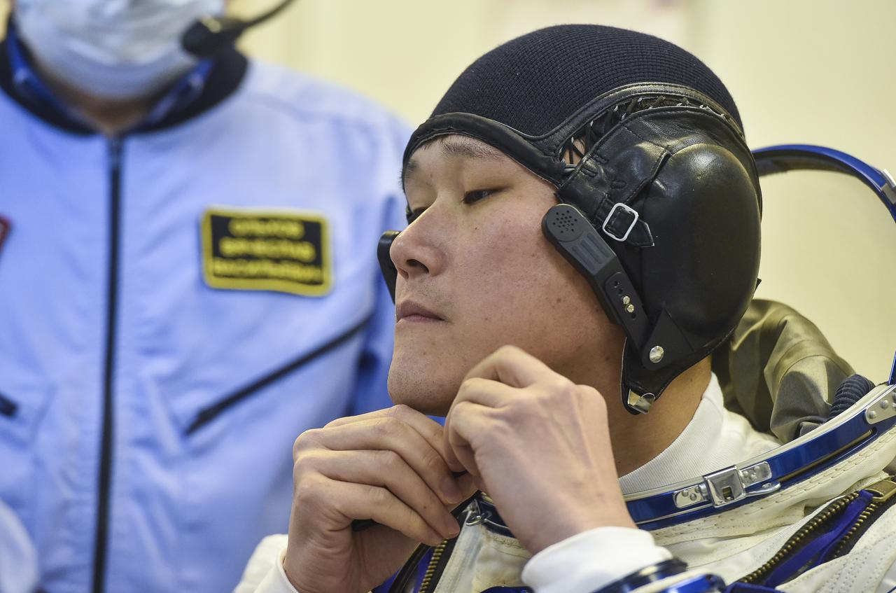 Expedition 54 flight engineer Norishige Kanai of the Japan Aerospace Exploration Agency (JAXA), left, is helped into his Russian Sokol suit as he and fellow cremates, Soyuz Commander Anton Shkaplerov of Roscosmos, center, and flight engineer Scott Tingle of NASA, right, prepare for their Soyuz launch to the International Space Station Sunday, Dec. 17, 2017 in Baikonur, Kazakhstan.  Launch of the Soyuz rocket will send Tingle, Kanai, and Shkaplerov on a five month mission aboard the International Space Station. Photo Credit: (NASA/GCTC/Andrey Shelepin)