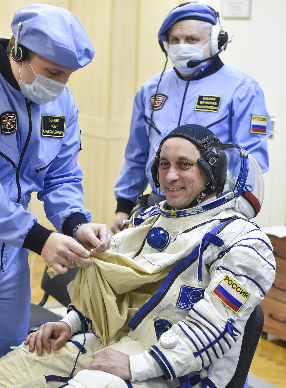 Expedition 54 Soyuz Commander Anton Shkaplerov of Roscosmos is helped into his Russian Sokol suit as he and fellow cremates, flight engineer Norishige Kanai of the Japan Aerospace Exploration Agency (JAXA) and flight engineer Scott Tingle of NASA prepare for their Soyuz launch to the International Space Station Sunday, Dec. 17, 2017 in Baikonur, Kazakhstan.  Launch of the Soyuz rocket will send Tingle, Kanai, and Shkaplerov on a five month mission aboard the International Space Station. Photo Credit: (NASA/GCTC/Andrey Shelepin)