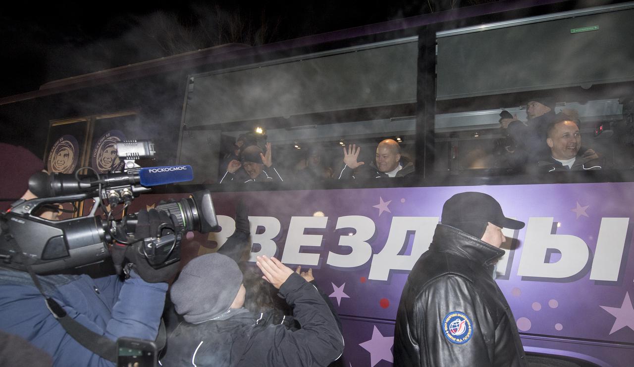 Expedition 54 flight engineer Norishige Kanai of the Japan Aerospace Exploration Agency (JAXA), left, and flight engineer Scott Tingle of NASA, center, and Soyuz Commander Anton Shkaplerov of Roscosmos, right, wave farewell to family and friends as they depart the Cosmonaut Hotel to suit-up for their Soyuz launch to the International Space Station, Sunday, Dec. 17, 2017 in Baikonur, Kazakhstan. Launch of the Soyuz rocket is scheduled for 2:21 a.m. Eastern Time (1:21 p.m. Baikonur time) on December 17 and will send Shkaplerov, Tingle, and Kanai on a five month mission aboard the International Space Station.  Photo Credit: (NASA/Joel Kowsky)