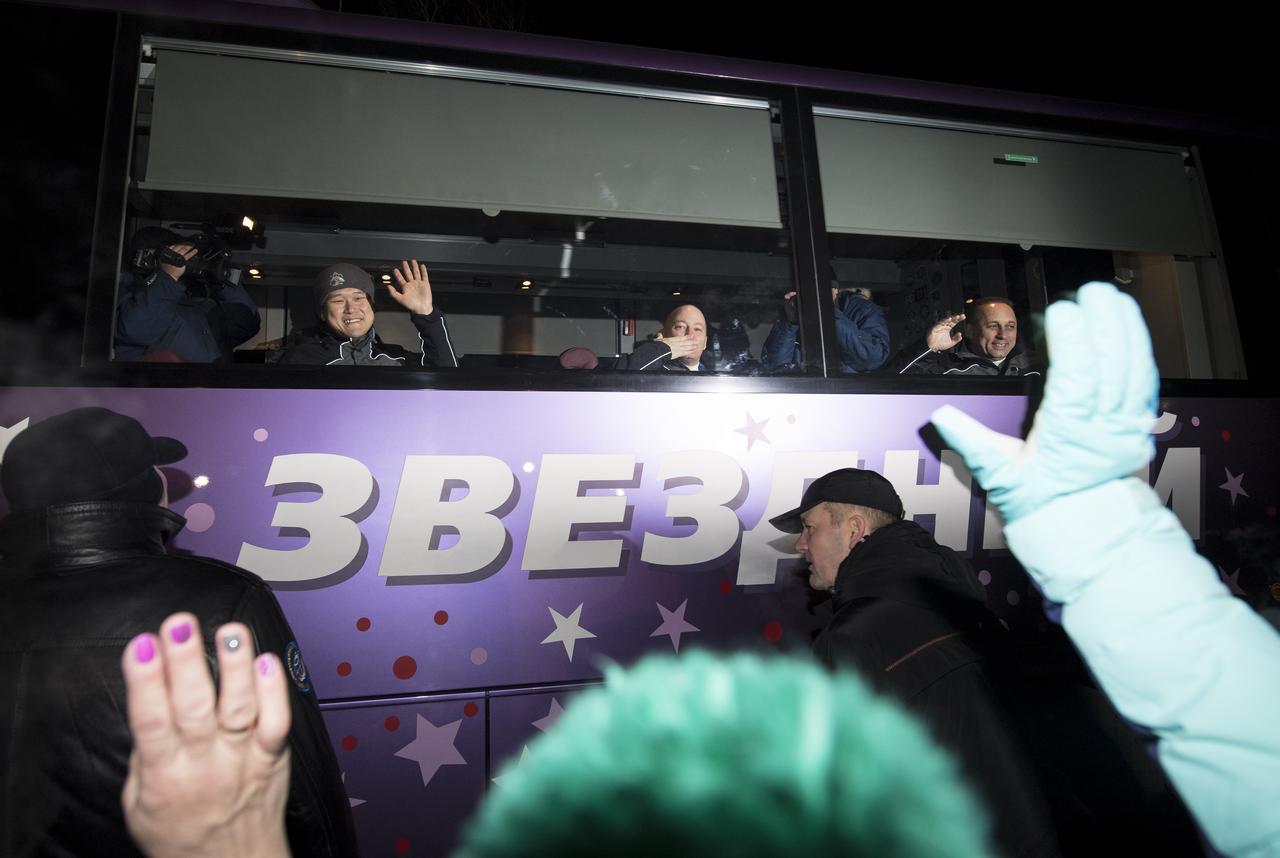 Expedition 54 flight engineer Norishige Kanai of the Japan Aerospace Exploration Agency (JAXA), left, and flight engineer Scott Tingle of NASA, center, and Soyuz Commander Anton Shkaplerov of Roscosmos, right, wave farewell to family and friends as they depart the Cosmonaut Hotel to suit-up for their Soyuz launch to the International Space Station, Sunday, Dec. 17, 2017 in Baikonur, Kazakhstan. Launch of the Soyuz rocket is scheduled for 2:21 a.m. Eastern Time (1:21 p.m. Baikonur time) on December 17 and will send Shkaplerov, Tingle, and Kanai on a five month mission aboard the International Space Station.  Photo Credit: (NASA/Joel Kowsky)
