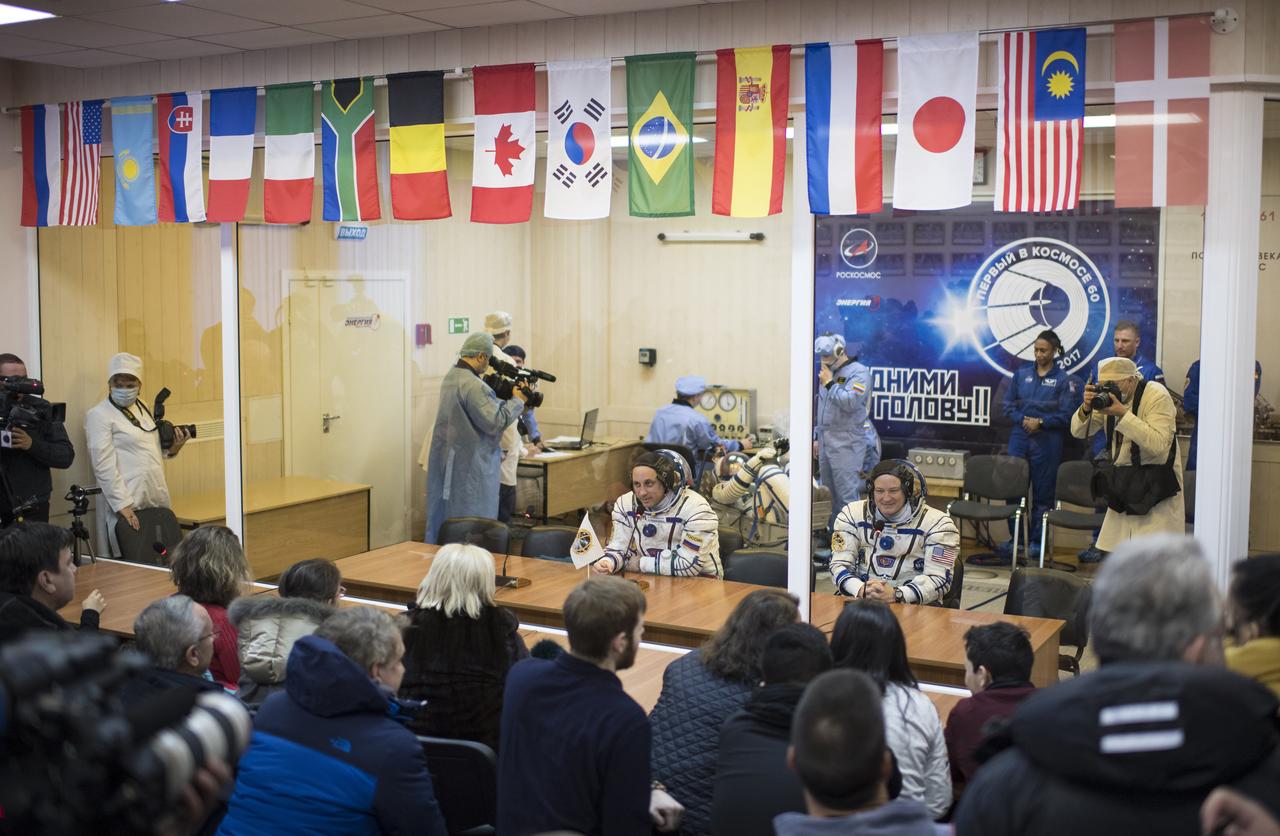 Expedition 54 flight engineer Scott Tingle of NASA, right, and Soyuz Commander Anton Shkaplerov of Roscosmos  speak with family and friends as flight engineer Norishige Kanai of the Japan Aerospace Exploration Agency (JAXA) has his Russian Sokol suit pressure checked in preparation for launch aboard the Soyuz MS-07 spacecraft, Sunday, Dec. 17, 2017 at the Baikonur Cosmodrome  Kazakhstan. Launch of the Soyuz rocket will send Tingle, Shkaplerov, and Kanai on a five month mission aboard the International Space Station.  Photo Credit: (NASA/Joel Kowsky)