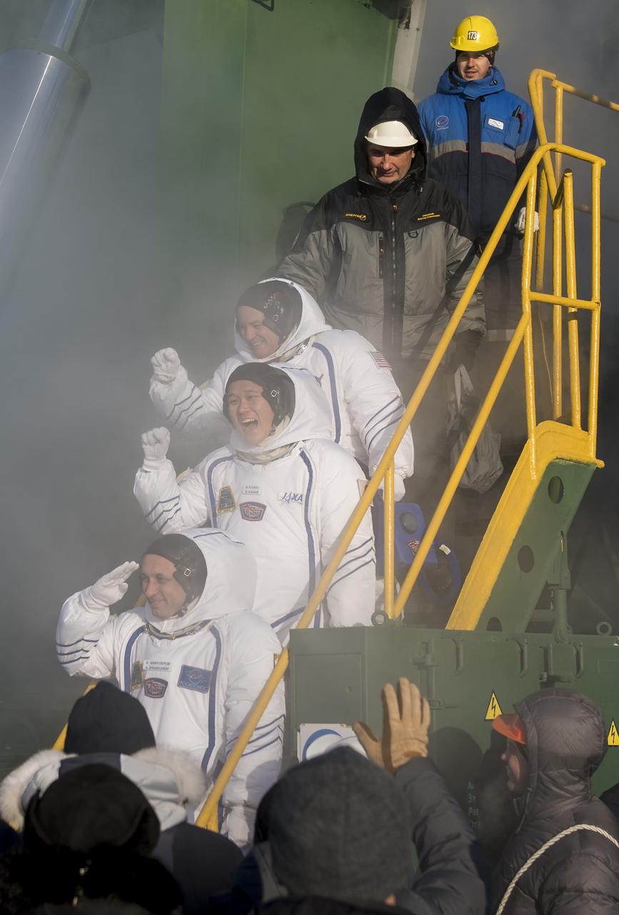 Expedition 54 flight engineer Scott Tingle of NASA, top, flight engineer Norishige Kanai of Japan Aerospace Exploration Agency (JAXA), middle, and Soyuz Commander Anton Shkaplerov of Roscosmos, bottom, wave farewell prior to boarding the Soyuz MS-07 rocket for launch, Sunday, Dec. 17, 2017 at the Baikonur Cosmodrome in Kazakhstan. Tingle, Norishige Kanai, and Shkaplerov will spend the next five months living and working aboard the International Space Station.  Photo Credit: (NASA/Joel Kowsky)