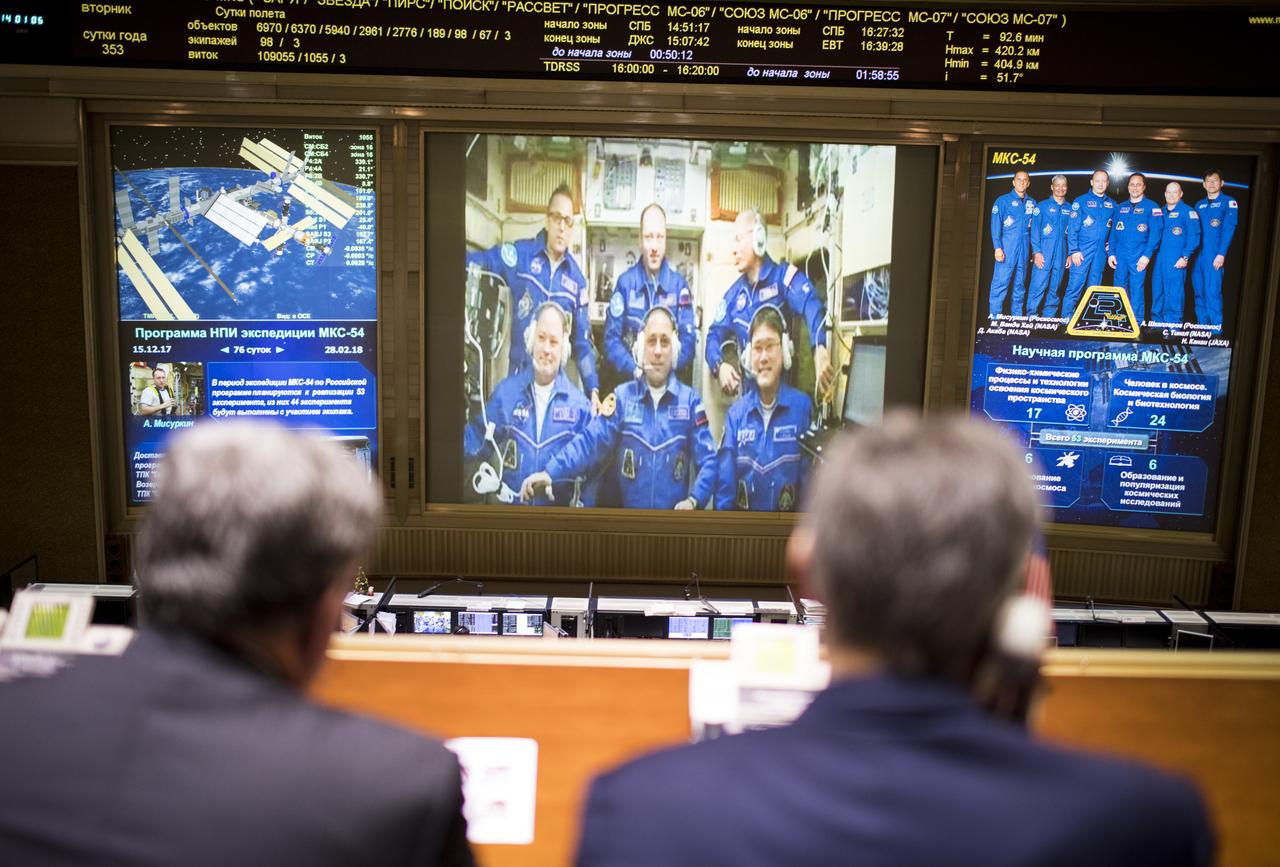 Expedition 54 flight engineers Scott Tingle of NASA, bottom left, Anton Shkaplerov of Roscosmos, bottom center, and Norishige Kanai of the Japan Aerospace Exploration Agency (JAXA) bottom right, are seen with flight engineer Joe Acaba of NASA, top left, Commander Alexander Misurkin, top center, and flight engineer Mark Vande Hei of NASA, top right, on a video monitor as they U.S. Ambassador to Russia Jon Huntsman Jr. at the Moscow Mission Control Center in Korolev, Russia a few hours after the Soyuz MS-07 docked to the International Space Station on Tuesday, Dec. 19, 2017. Photo Credit: (NASA/Joel Kowsky)