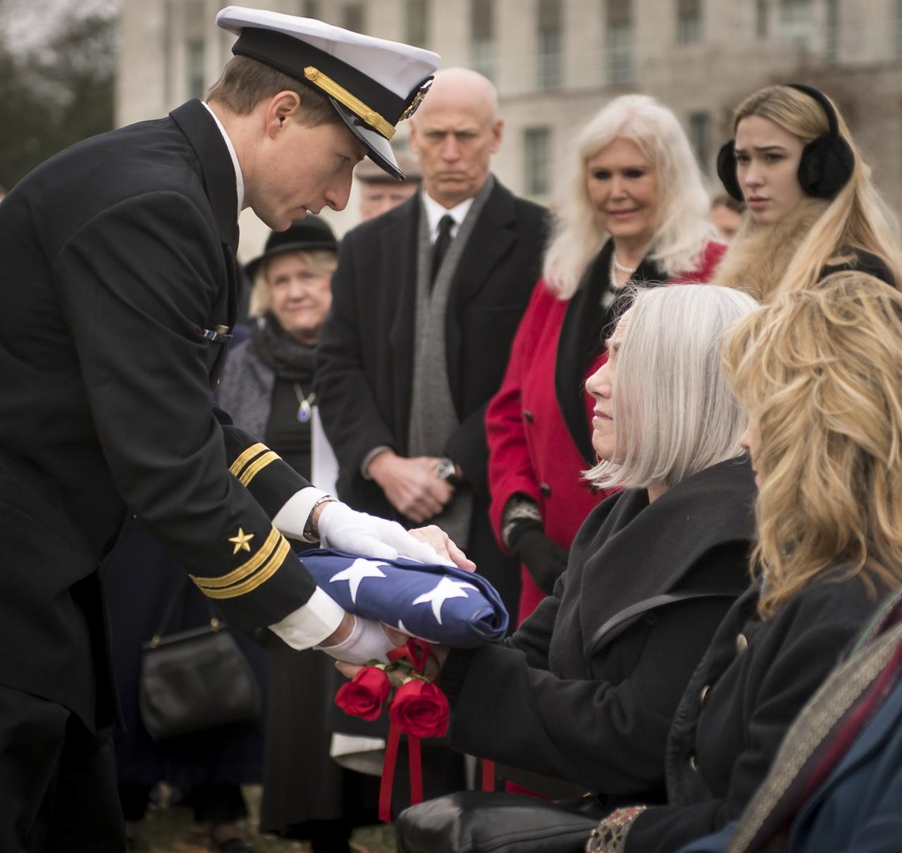 The flag that draped the casket of former NASA astronaut Captain Bruce McCandless II, USN (Ret.) is presented to his wife Ellen Shields McCandless during his interment service, Tuesday, Jan. 16, 2018 at the United States Naval Academy Cemetery in Annapolis, Maryland. Photo Credit: (NASA/Bill Ingalls)