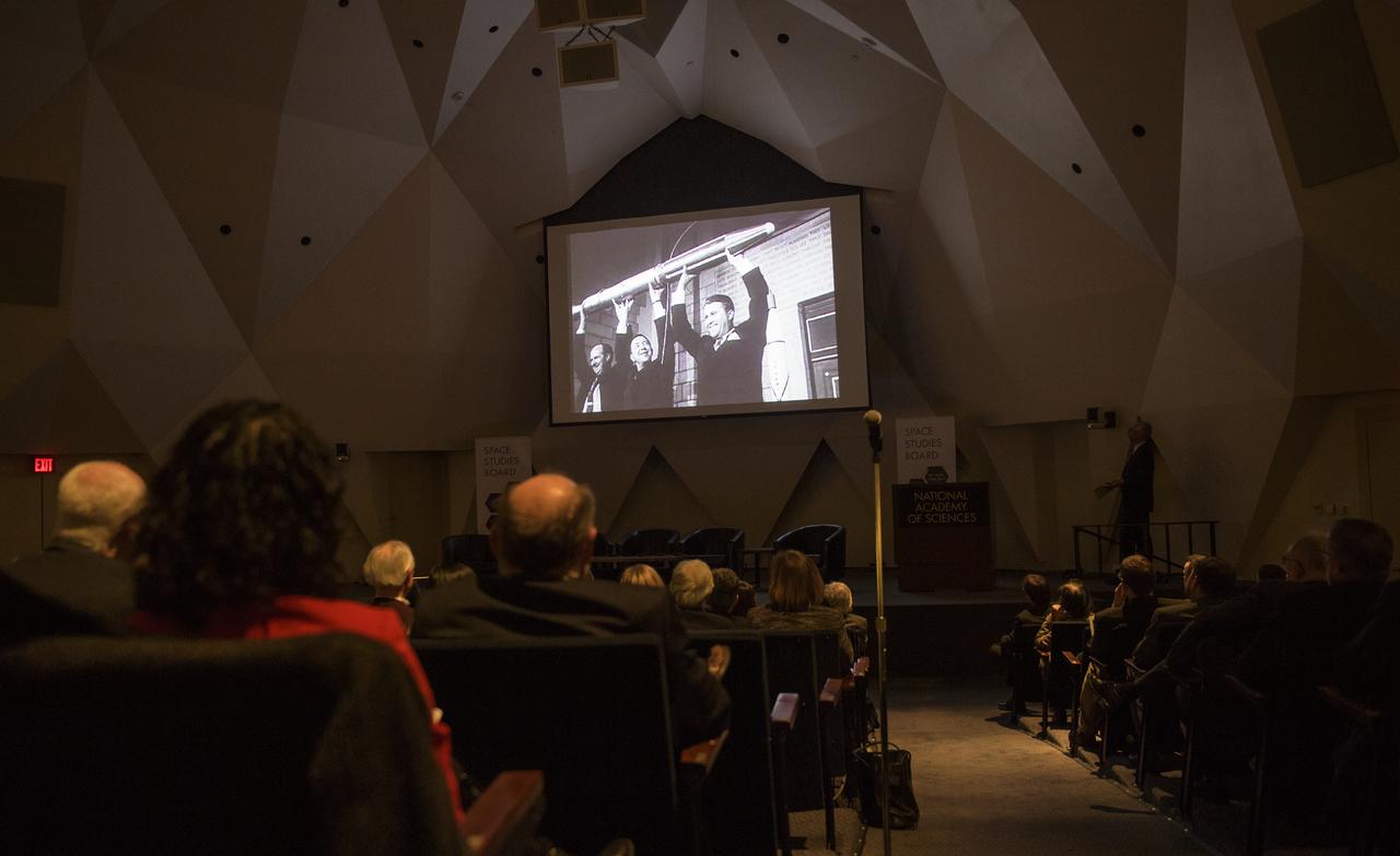 Attendees watch a short video on Explorer 1 during an event celebrating the 60th Anniversary of the Explorer 1 mission and the discovery of Earth's radiation belts, Wednesday, Jan. 31, 2018, at the National Academy of Sciences in Washington. The first U.S. satellite, Explorer 1, was launched from Cape Canaveral on January 31, 1958. The 30-pound satellite would yield a major scientific discovery, the Van Allen radiation belts circling our planet, and begin six decades of groundbreaking space science and human exploration. (NASA/Joel Kowsky)