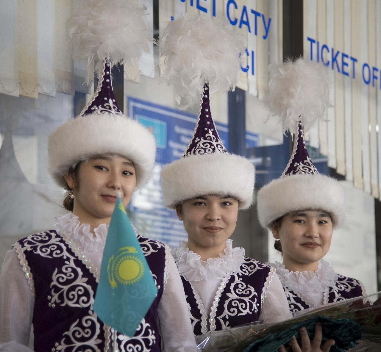 Girls in ceremonial Kazak dress wait to welcome the return of Expedition 54 crew members Joe Acaba and Mark Vande Hei of NASA and cosmonaut Alexander Misurkin at a Zhezkazgan Airport welcome ceremony in Kazakhstan on Wednesday, Feb. 28, 2018. 2018 (February 27 Eastern time.)  Acaba, Vande Hei, and Misurkin are returning after 168 days in space where they served as members of the Expedition 53 and 54 crews onboard the International Space Station. Photo Credit: (NASA/Bill Ingalls)