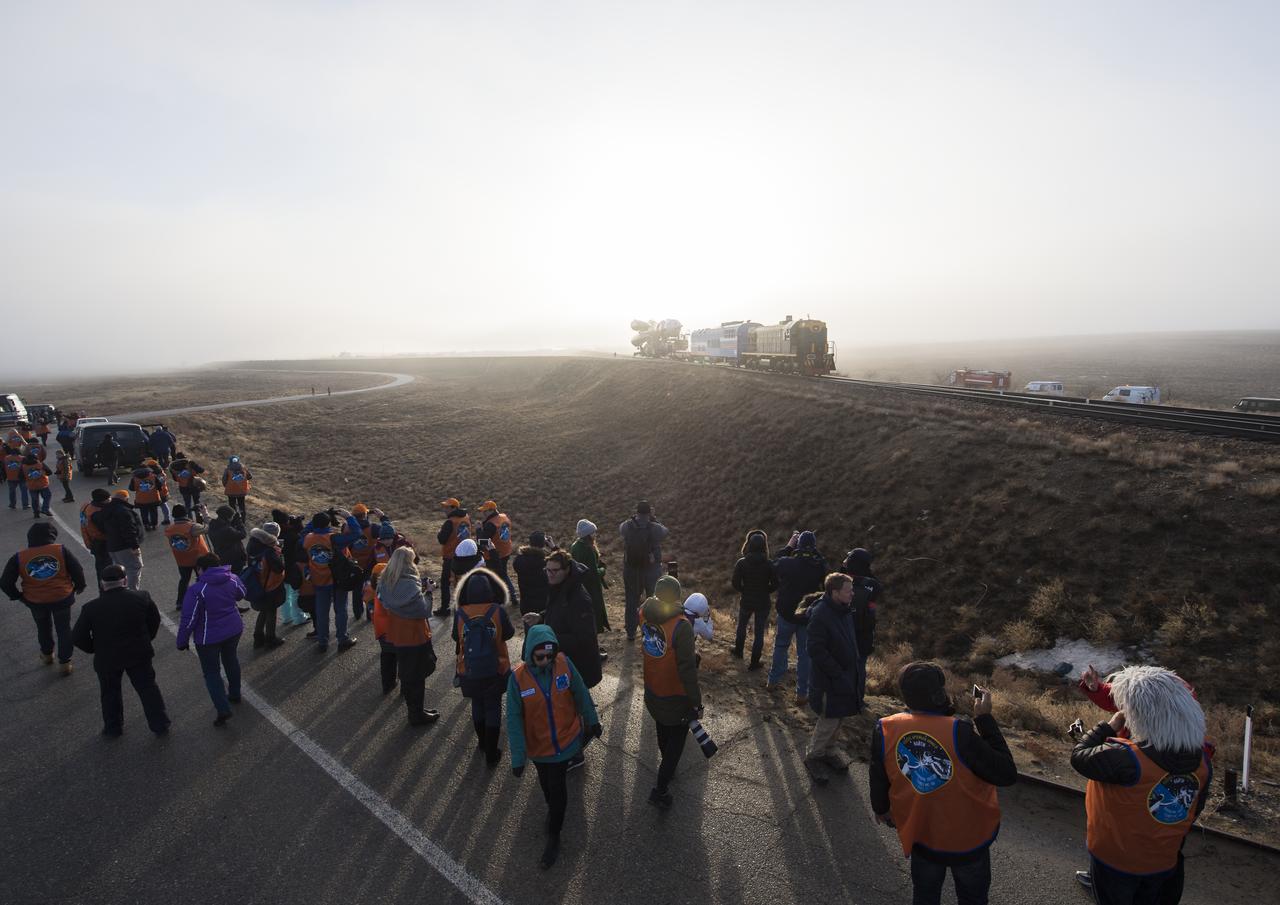 Launch guests watch as the Soyuz rocket is rolled out by train to the launch pad, Monday, March 19, 2018 at the Baikonur Cosmodrome in Kazakhstan. Expedition 55 crewmembers Ricky Arnold and Drew Feustel of NASA and Oleg Artemyev of Roscosmos are scheduled to launch at 1:44 p.m. Eastern time (11:44 p.m. Baikonur time) on March 21 and will spend the next five months living and working aboard the International Space Station. Photo Credit: (NASA/Joel Kowsky)