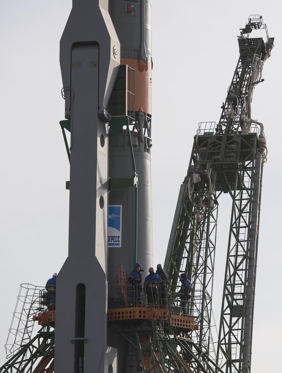 Workers are seen on a gantry after the Soyuz rocket was raised into a vertical position on the launch pad, Monday, March 19, 2018 at the Baikonur Cosmodrome in Kazakhstan. Expedition 55 crewmembers Ricky Arnold and Drew Feustel of NASA and Oleg Artemyev of Roscosmos are scheduled to launch at 1:44 p.m. Eastern time (11:44 p.m. Baikonur time) on March 21 and will spend the next five months living and working aboard the International Space Station. Photo Credit: (NASA/Joel Kowsky)