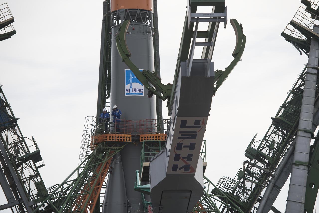 Workers are seen on a gantry after the Soyuz rocket was raised into a vertical position on the launch pad, Monday, March 19, 2018 at the Baikonur Cosmodrome in Kazakhstan. Expedition 55 crewmembers Ricky Arnold and Drew Feustel of NASA and Oleg Artemyev of Roscosmos are scheduled to launch at 1:44 p.m. Eastern time (11:44 p.m. Baikonur time) on March 21 and will spend the next five months living and working aboard the International Space Station. Photo Credit: (NASA/Joel Kowsky)