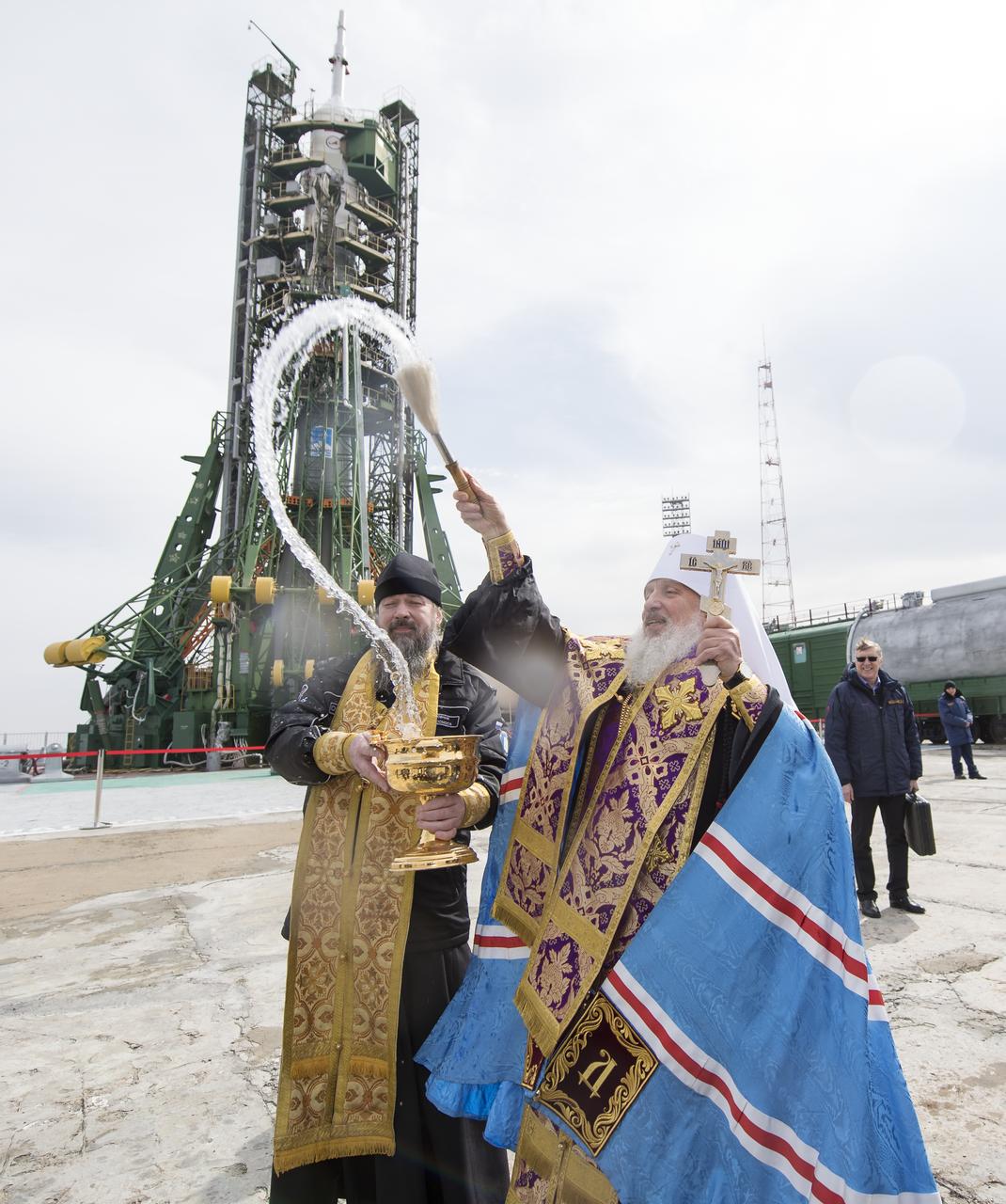 An Orthodox Priest blesses members of the media at the Baikonur Cosmodrome launch pad, Tuesday, March 20, 2018 in Baikonur, Kazakhstan. Expedition 55 Soyuz Commander Oleg Artemyev of Roscosmos, Ricky Arnold and Drew Feustel of NASA are scheduled to launch to the International Space Station aboard the Soyuz MS-08 spacecraft on Wednesday, March, 21. Photo Credit: (NASA/Joel Kowsky)