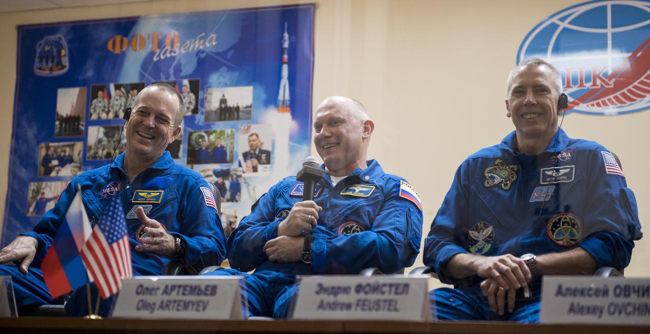 Expedition 55 prime crew members Ricky Arnold of NASA, left, Oleg Artemyev of Roscosmos, center, and Drew Feustel of NASA, right, are seen in quarantine, behind glass, during a press conference, Tuesday, March 20, 2018 a the Cosmonaut Hotel in Baikonur, Kazakhstan. Expedition 55 Soyuz Commander Oleg Artemyev of Roscosmos, Ricky Arnold and Drew Feustel of NASA are scheduled to launch to the International Space Station aboard the Soyuz MS-08 spacecraft on Wednesday, March, 21. Photo Credit: (NASA/Joel Kowsky)