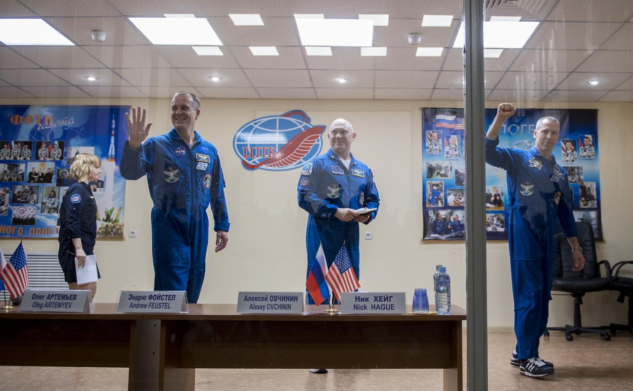 Expedition 55 flight engineer Ricky Arnold of NASA, left, Soyuz Commander Oleg Artemyev of Roscosmos, center, and flight engineer Drew Feustel of NASA, right, are seen at the conclusion of a press conference, Tuesday, March 20, 2018 a the Cosmonaut Hotel in Baikonur, Kazakhstan. Arnold, Artemyev, and Feustel are scheduled to launch to the International Space Station aboard the Soyuz MS-08 spacecraft on Wednesday, March, 21.  Photo Credit: (NASA/Joel Kowsky)