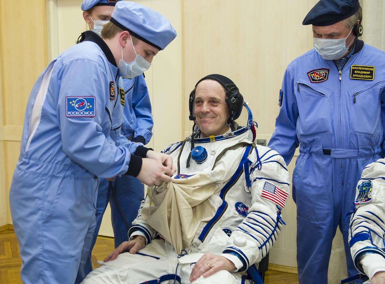 Expedition 55 flight engineer Ricky Arnold of NASA is helped into his Russian Sokol suit as he and fellow crewmates, Soyuz Commander Oleg Artemyev of Roscosmos and flight engineer Drew Feustel of NASA prepare for their Soyuz launch to the International Space Station Wednesday, March 21, 2018 in Baikonur, Kazakhstan. Arnold, Artemyev, and Feustel launched aboard the Soyuz MS-08 spacecraft at 1:44 p.m. Eastern time (11:44 p.m. Baikonur time) on March 21 to begin their journey to the International Space Station. Photo Credit: (NASA/GCTC/Irina Peshkova)