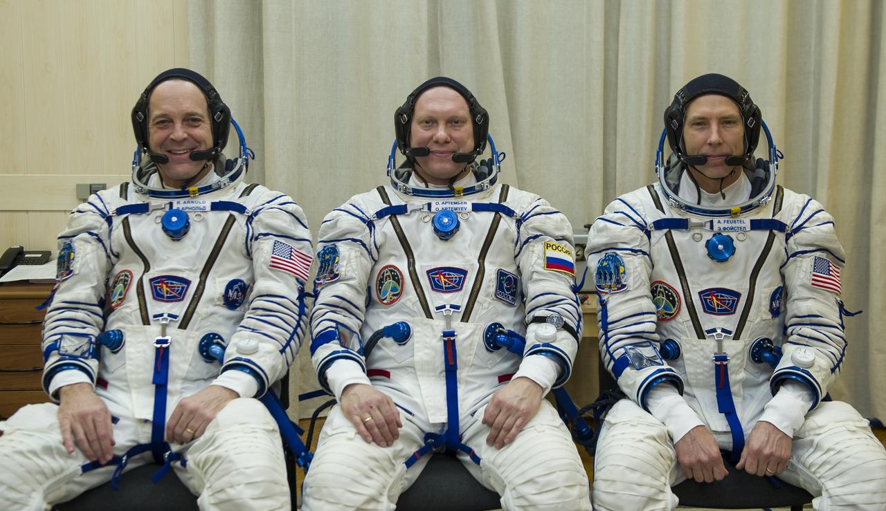 Expedition 55 flight engineer Ricky Arnold of NASA, left, Soyuz Commander Oleg Artemyev of Roscosmos, center, and flight engineer Drew Feustel of NASA, right, pose for a picture after donning their Russian Sokol suits as they prepare for their Soyuz launch to the International Space Station Wednesday, March 21, 2018 in Baikonur, Kazakhstan. Arnold, Artemyev, and Feustel launched aboard the Soyuz MS-08 spacecraft at 1:44 p.m. Eastern time (11:44 p.m. Baikonur time) on March 21 to begin their journey to the International Space Station. Photo Credit: (NASA/GCTC/Irina Peshkova)