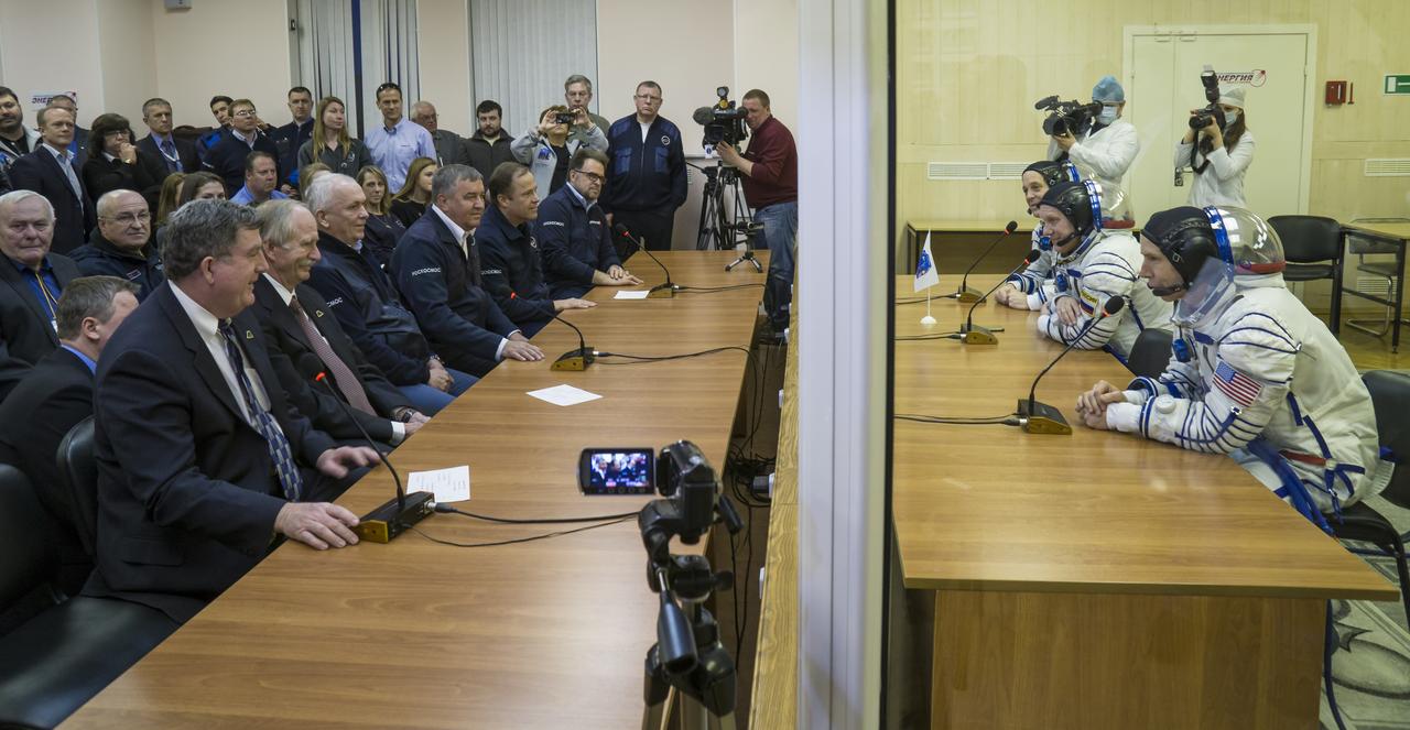 Expedition 55 flight engineer Ricky Arnold of NASA, Soyuz Commander Oleg Artemyev of Roscosmos, and flight engineer Drew Feustel of NASA talk to Roscosmos and NASA management after having their Russian Sokol suits pressure checked ahead of their launch on a Soyuz rocket, Wednesday, March 21, 2018 at the Baikonur Cosmodrome  Kazakhstan. Arnold, Artemyev, and Feustel launched aboard the Soyuz MS-08 spacecraft at 1:44 p.m. Eastern time (11:44 p.m. Baikonur time) on March 21 to begin their journey to the International Space Station.  Photo Credit: (NASA/Victor Zelentsov)