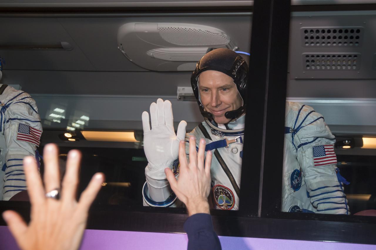 Expedition 55 flight engineer Drew Feustel of NASA waves farewell to family and friends as he and Soyuz Commander Oleg Artemyev of Roscosmos and flight engineer Ricky Arnold of NASA depart for the launch pad a few hours before their launch, Wednesday, March 21, 2018 at the Baikonur Cosmodrome Kazakhstan. Launch of the Soyuz rocket will send Feustel, Artemyev, and Arnold on a five month mission aboard the International Space Station. Photo Credit: (NASA/Victor Zelentsov)