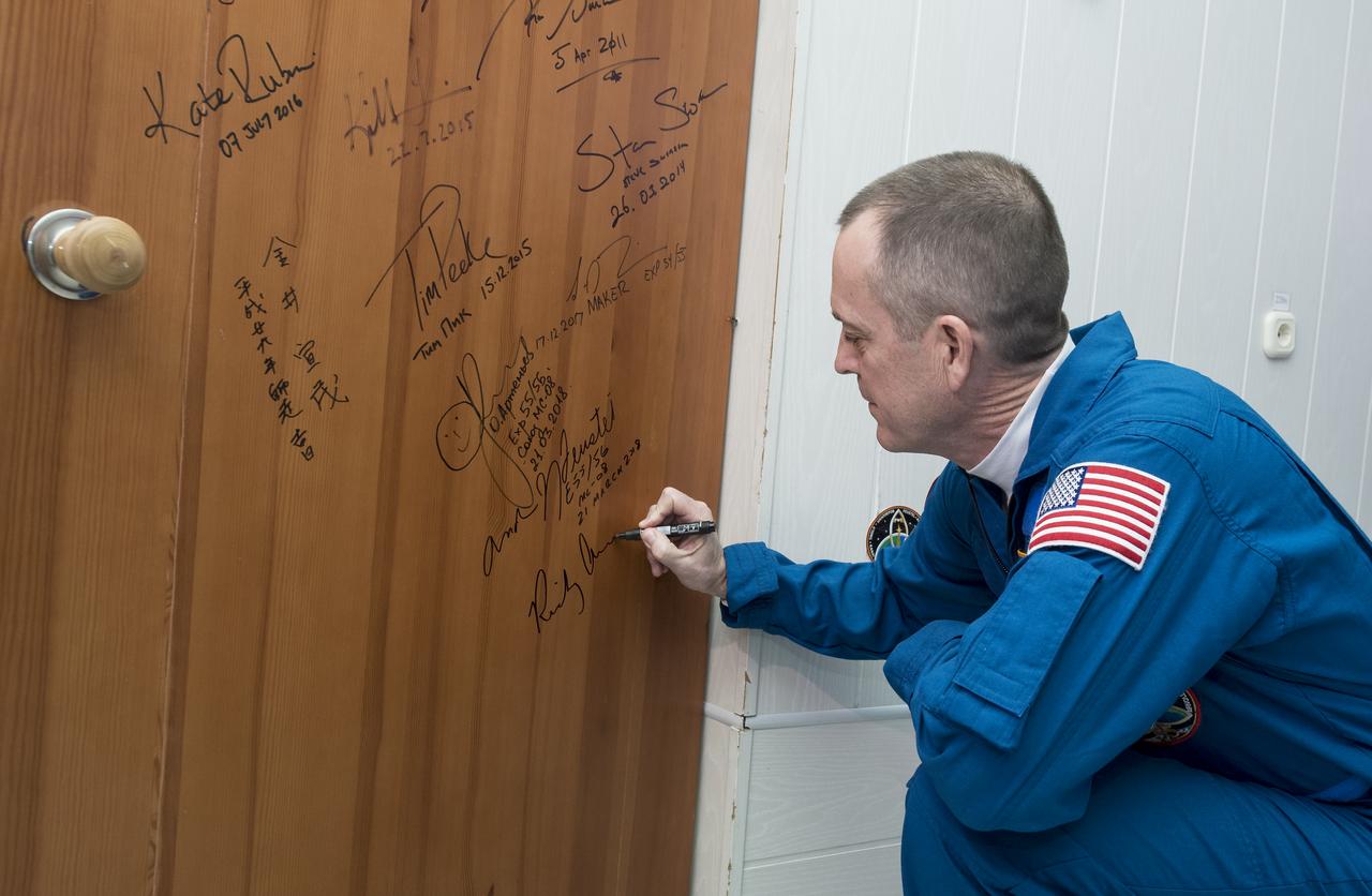 Expedition 55 flight engineer Ricky Arnold of NASA performs the traditional door signing at the Cosmonaut Hotel prior to departing the hotel for launch on a Soyuz rocket with fellow crewmates Oleg Artemyev of Roscosmos and Drew Feustel of NASA, Wednesday, March 21, 2018 in Baikonur, Kazakhstan. Arnold, Artemyev, and Feustel will launch in their Soyuz MS-08 spacecraft to the International Space Station to begin a five month mission. Photo Credit: (NASA/Joel Kowsky)