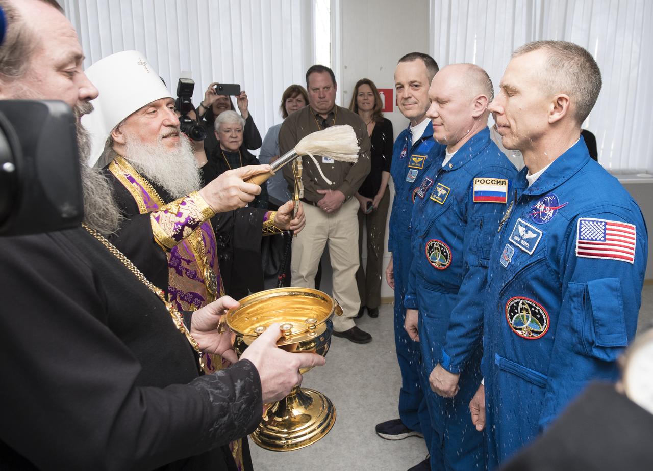 Expedition 55 flight engineer Ricky Arnold of NASA, Soyuz Commander Oleg Artemyev of Roscosmos, and flight engineer Drew Feustel of NASA receive a blessing from a Russian Orthodox Priest at the Cosmonaut Hotel prior to departing the hotel for launch on a Soyuz rocket, Wednesday, March 21, 2018 in Baikonur, Kazakhstan.  Arnold, Artemyev, and Feustel will launch in their Soyuz MS-08 spacecraft to the International Space Station to begin a five month mission.  Photo Credit: (NASA/Joel Kowsky)
