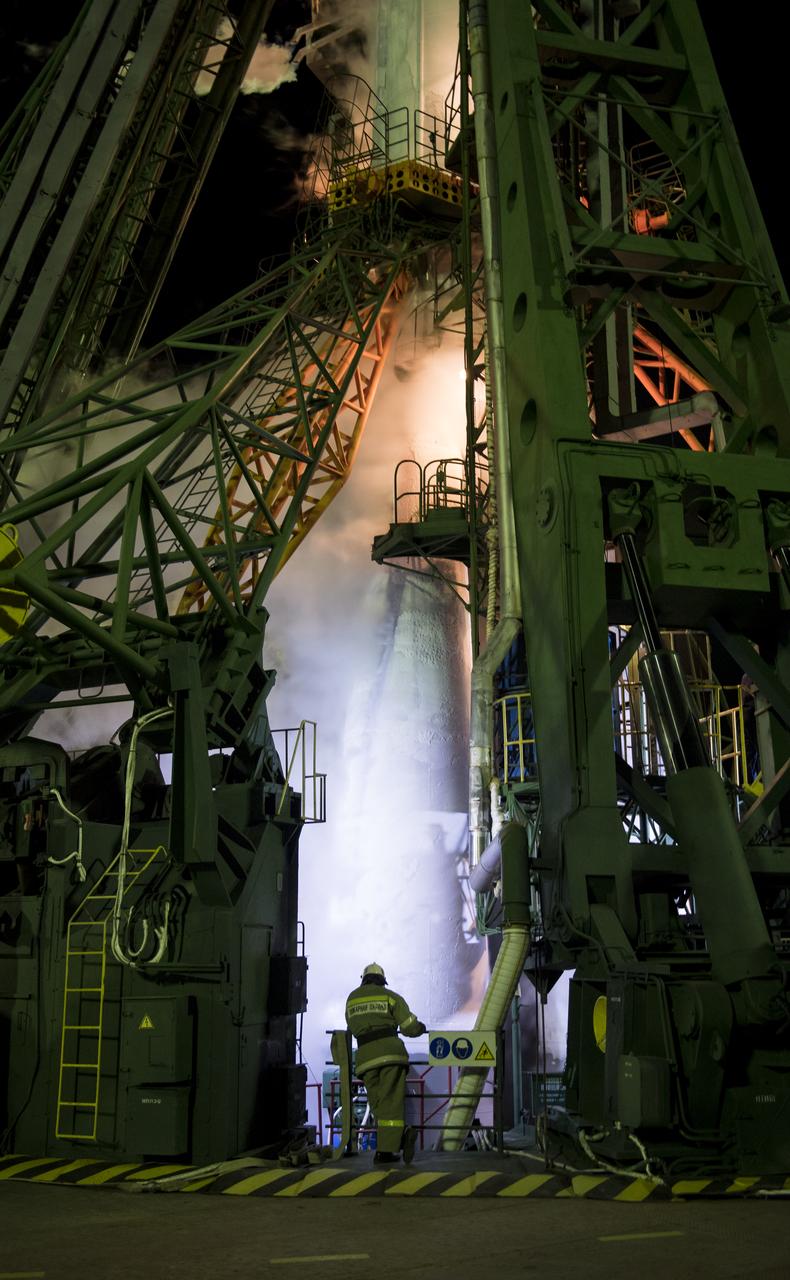 A firefighter is seen in front of the Soyuz rocket as teams await the arrival of Expedition 55 crew members Oleg Artemyev of Roscosmos, Ricky Arnold of NASA, and Drew Feustel of NASA, Wednesday, March 21, 2018 at the Baikonur Cosmodrome in Kazakhstan. Arnold, Artemyev, and Feustel launched aboard the Soyuz MS-08 spacecraft at 1:44 p.m. Eastern time (11:44 p.m. Baikonur time) on March 21 to begin their journey to the International Space Station. Photo Credit: (NASA/Joel Kowsky)