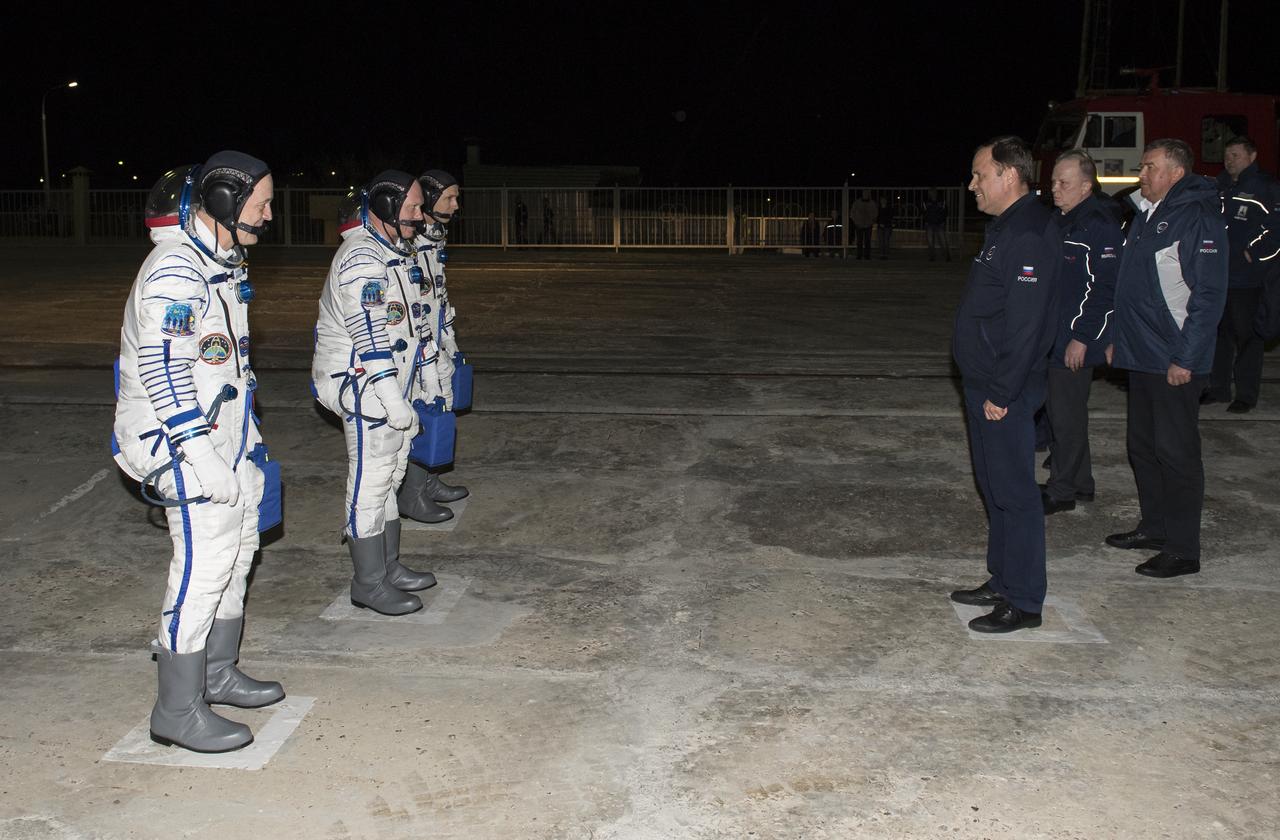 Expedition 55 Soyuz Commander Oleg Artemyev of Roscosmos and flight engineers Ricky Arnold and Drew Feustel of NASA report to Igor Komarov, Director of Roscosmos, prior to boarding the Soyuz MS-08 spacecraft, Wednesday, March 21, 2018 at the Baikonur Cosmodrome in Kazakhstan. Arnold, Artemyev, and Feustel launched aboard the Soyuz MS-08 spacecraft at 1:44 p.m. Eastern time (11:44 p.m. Baikonur time) on March 21 to begin their journey to the International Space Station.  Photo Credit: (NASA/Joel Kowsky)