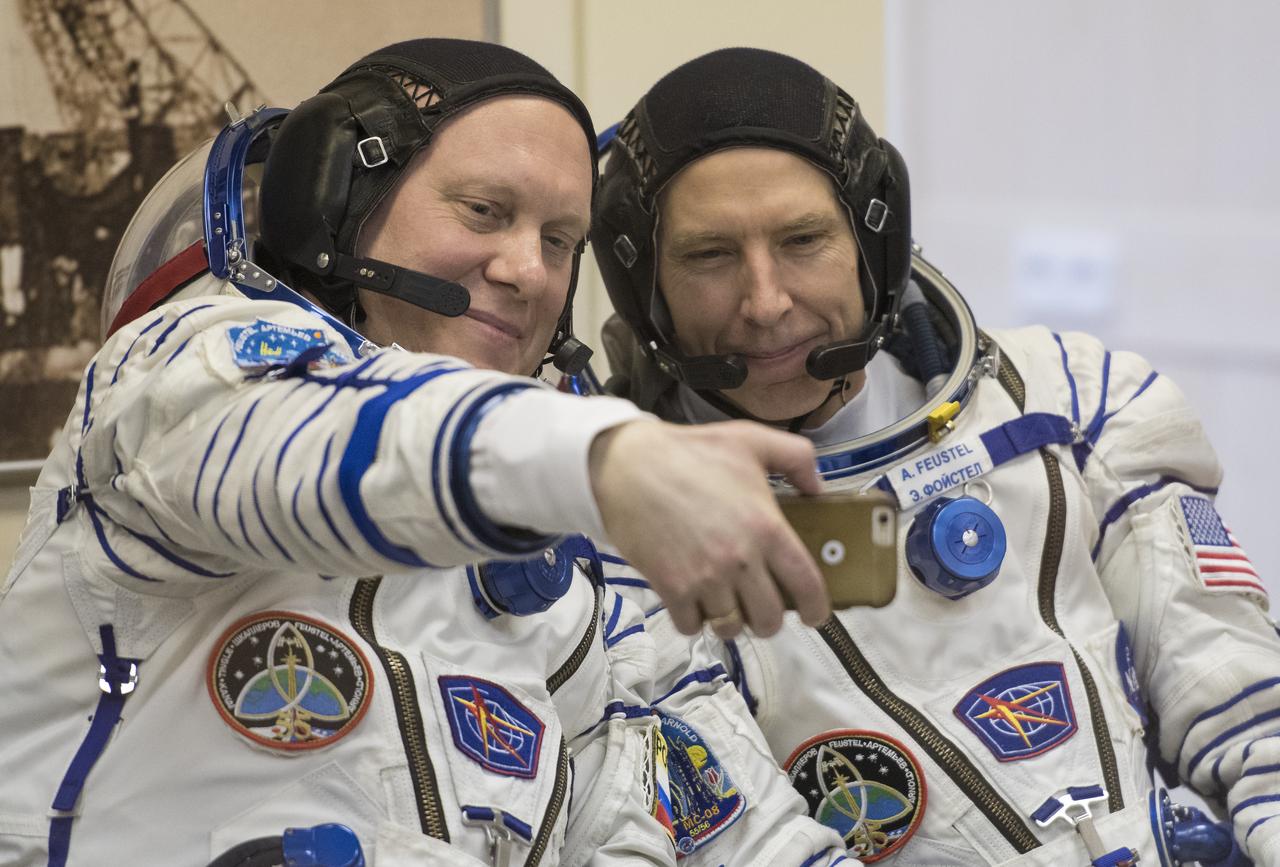 Expedition 55 Soyuz Commander Oleg Artemyev of Roscosmos, left, and flight engineer Drew Feustel of NASA take a selfie after having their Russian Sokol suits pressure checked in preparation for launch aboard the Soyuz MS-08 spacecraft, Wednesday, March 21, 2018 at the Baikonur Cosmodrome in Kazakhstan. Artemyev, Feustel, and flight engineer Ricky Arnold of NASA launched aboard the Soyuz MS-08 spacecraft at 1:44 p.m. Eastern time (11:44 p.m. Baikonur time) on March 21 to begin their journey to the International Space Station.  Photo Credit: (NASA/Joel Kowsky)