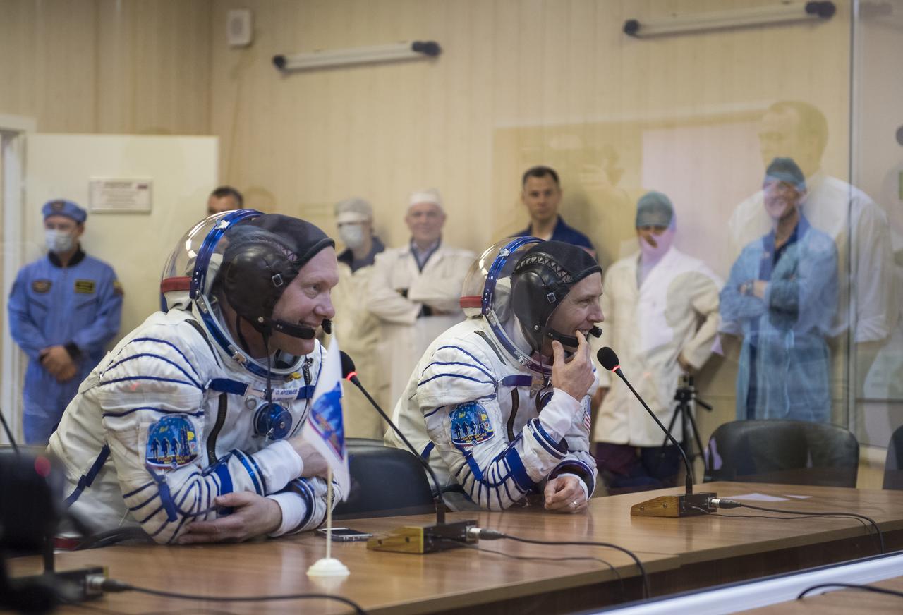 Expedition 55 Soyuz Commander Oleg Artemyev of Roscosmos, left, and flight engineer Drew Feustel of NASA, right, talk with family and friends after having their Russian Sokol suits pressure checked in preparation for launch aboard the Soyuz MS-08 spacecraft, Wednesday, March 21, 2018 at the Baikonur Cosmodrome in Kazakhstan. Artemyev, Feustel, and flight engineer Ricky Arnold of NASA launched aboard the Soyuz MS-08 spacecraft at 1:44 p.m. Eastern time (11:44 p.m. Baikonur time) on March 21 to begin their journey to the International Space Station.  Photo Credit: (NASA/Joel Kowsky)
